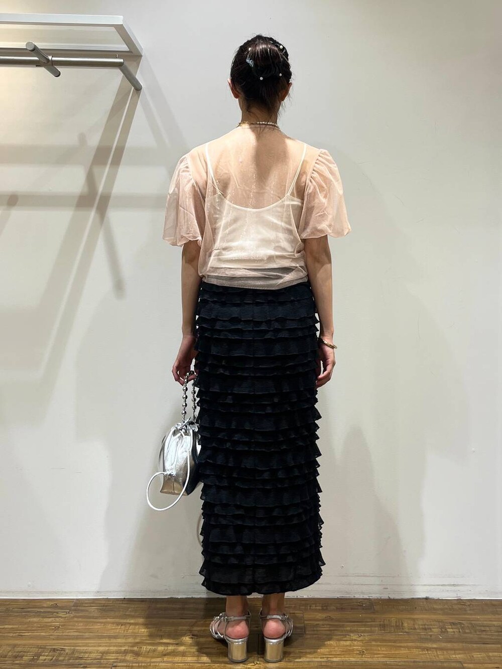 ブラック系のスカート、シルバー系のショルダーバッグ、シルバー系のサンダルを着用したレディースの春コーディネートの5枚目の写真