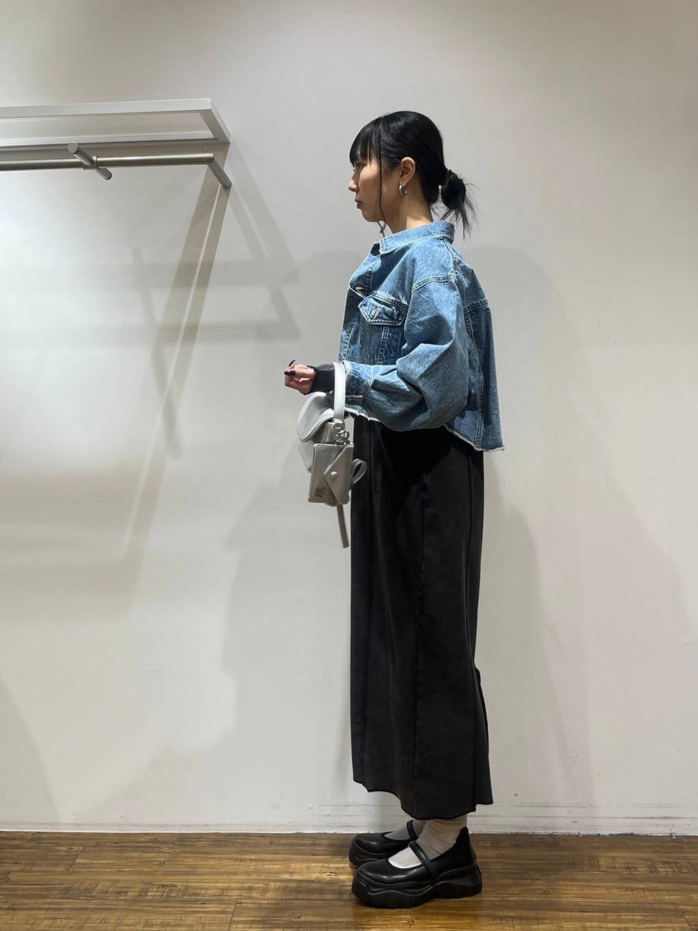ブラック系のスニーカー、ブルー系のデニムジャケット、シルバー系のショルダーバッグを着用したレディースの冬コーディネートの3枚目の写真