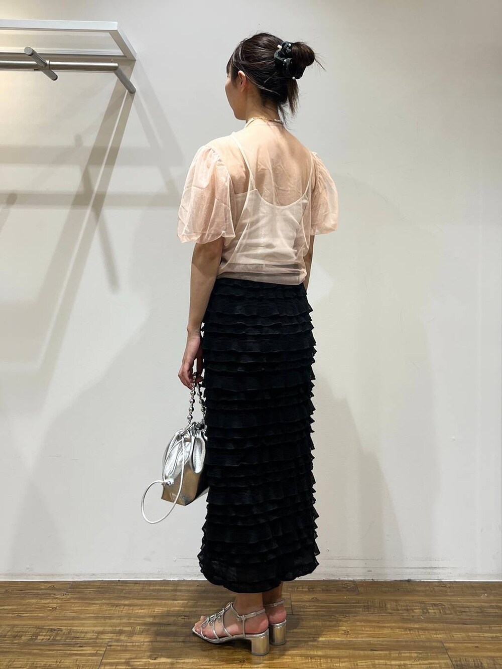 ブラック系のスカート、シルバー系のショルダーバッグ、シルバー系のサンダルを着用したレディースの春コーディネートの3枚目の写真