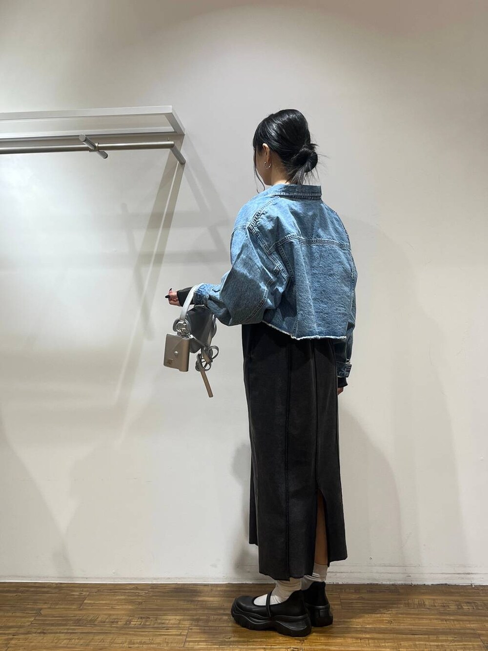 ブラック系のスニーカー、ブルー系のデニムジャケット、シルバー系のショルダーバッグを着用したレディースの冬コーディネートの2枚目の写真