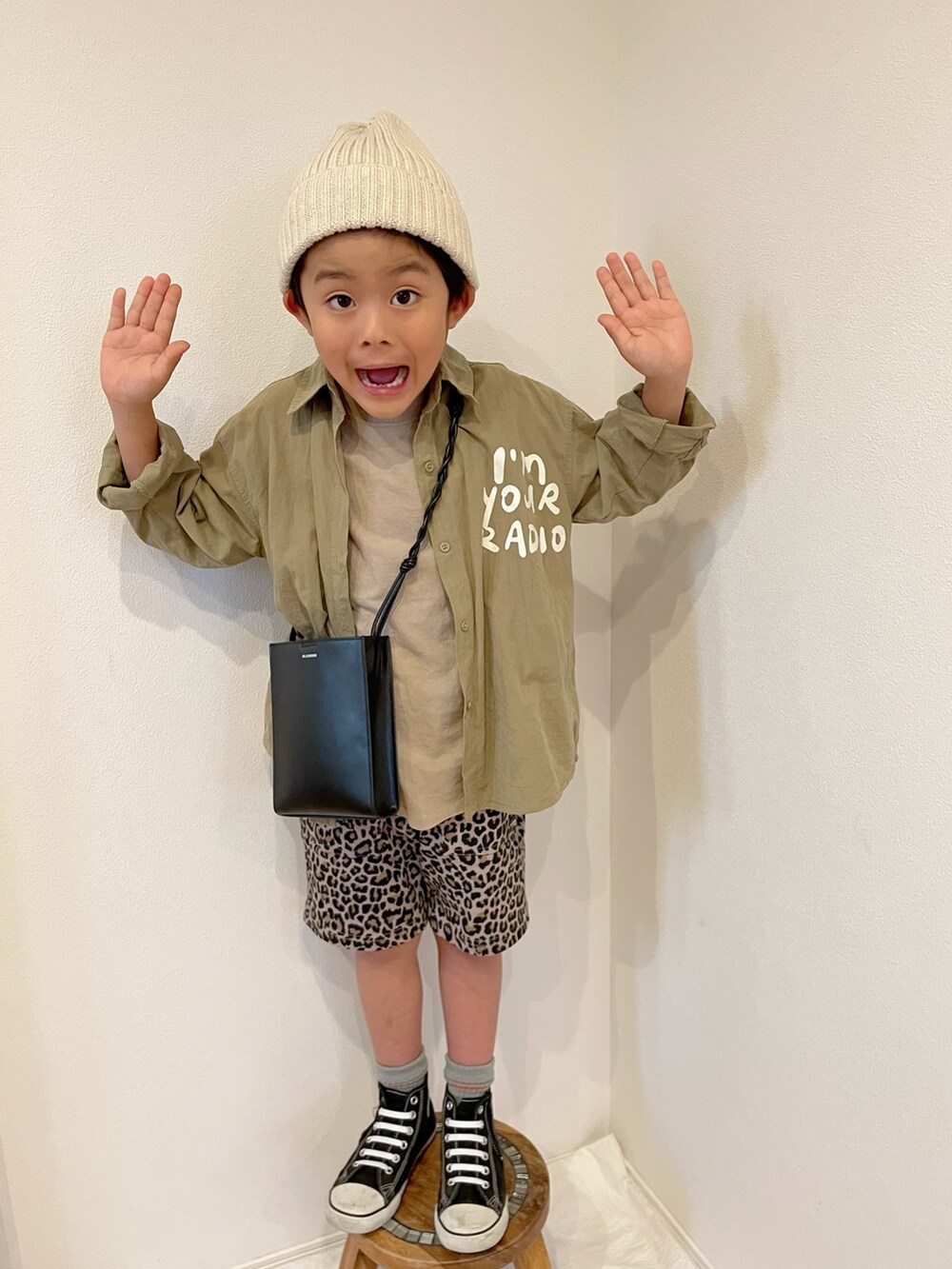 ブラック系のスニーカー、ブラウン系のその他パンツ、ブラック系のハンドバッグを着用したキッズの春コーディネートの2枚目の写真