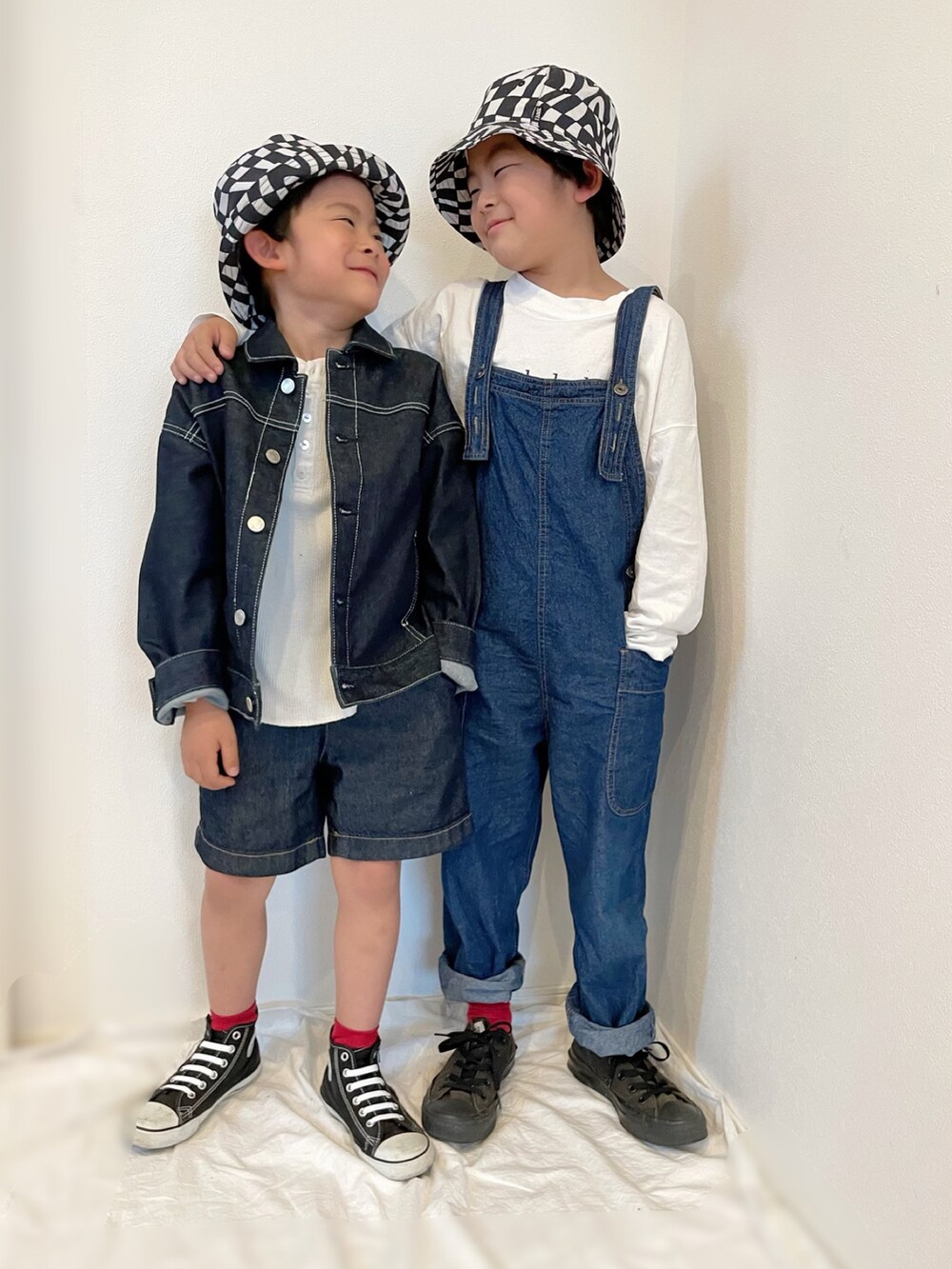 ブルー系のデニムジャケット、ブルー系のサロペット/オーバーオール、ブラック系のスニーカーを着用したキッズの春コーディネートの2枚目の写真