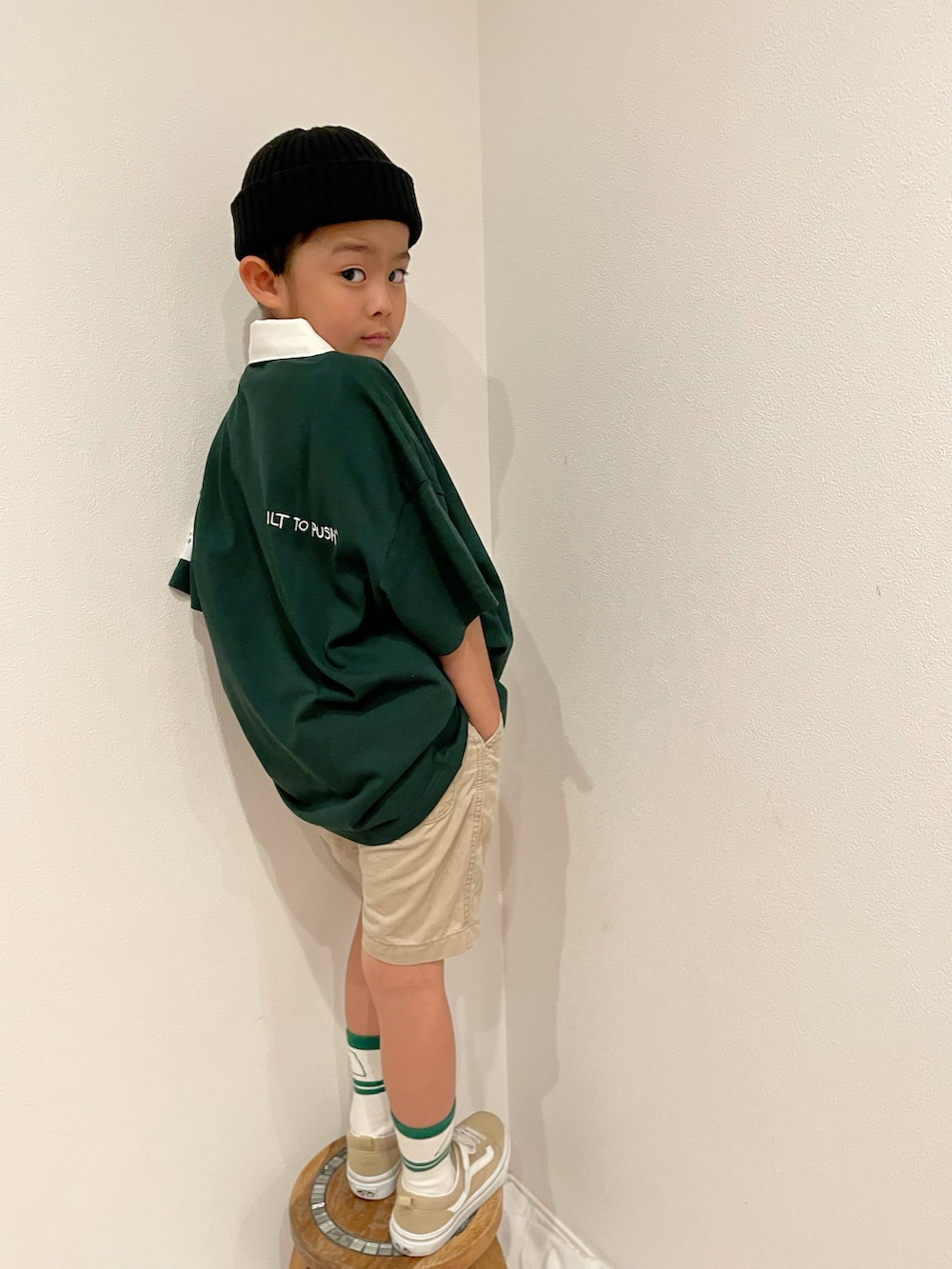 グリーン系のポロシャツ、ベージュ系のパンツ、ベージュ系のスニーカーを着用したキッズの春コーディネートの2枚目の写真