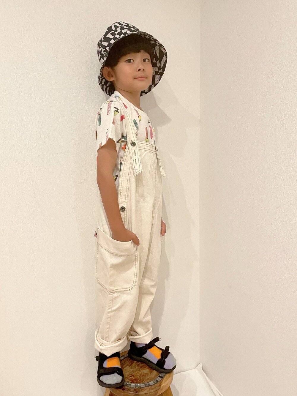 ホワイト系のサロペット/オーバーオール、ホワイト系のトップス、ブラック系のサンダルを着用したキッズの夏コーディネートの2枚目の写真