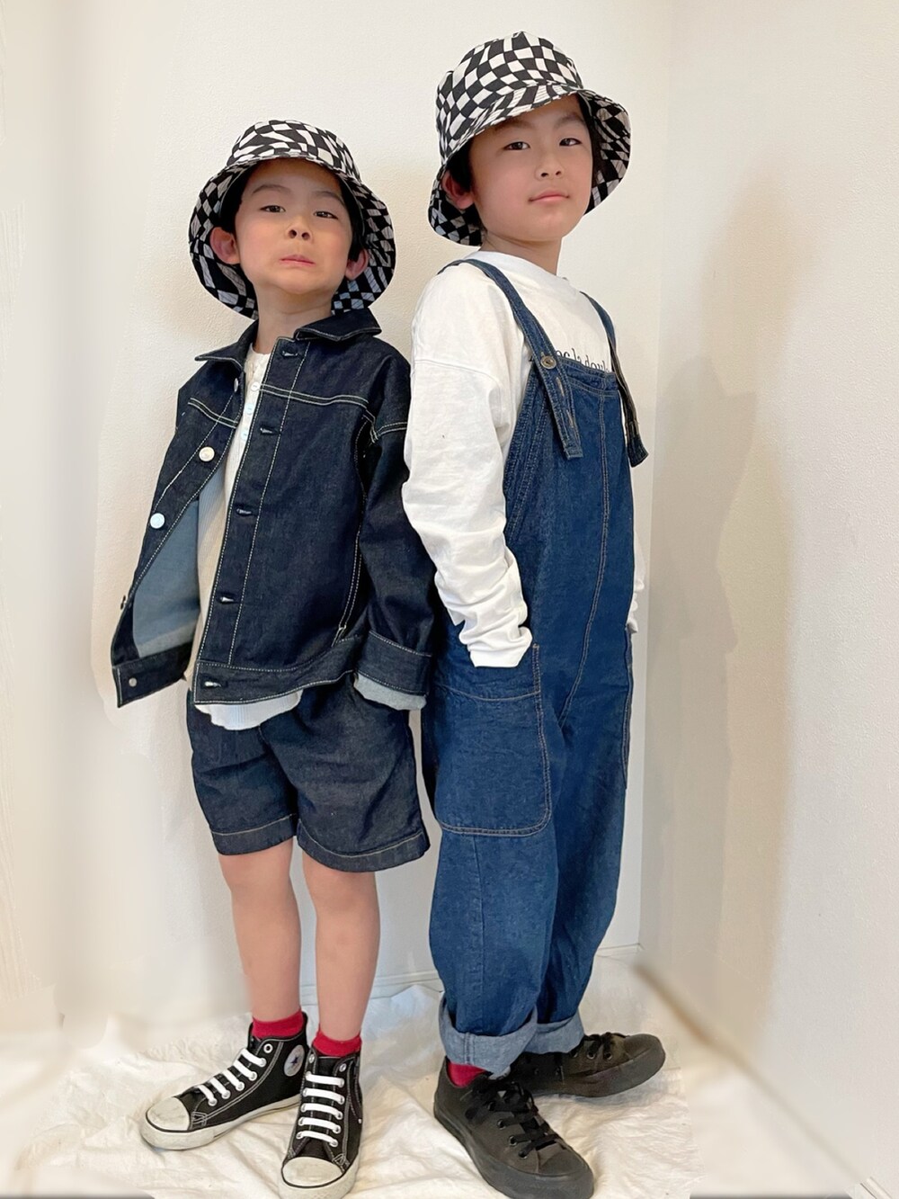 ブルー系のデニムジャケット、ブルー系のサロペット/オーバーオール、ブラック系のスニーカーを着用したキッズの春コーディネートの3枚目の写真