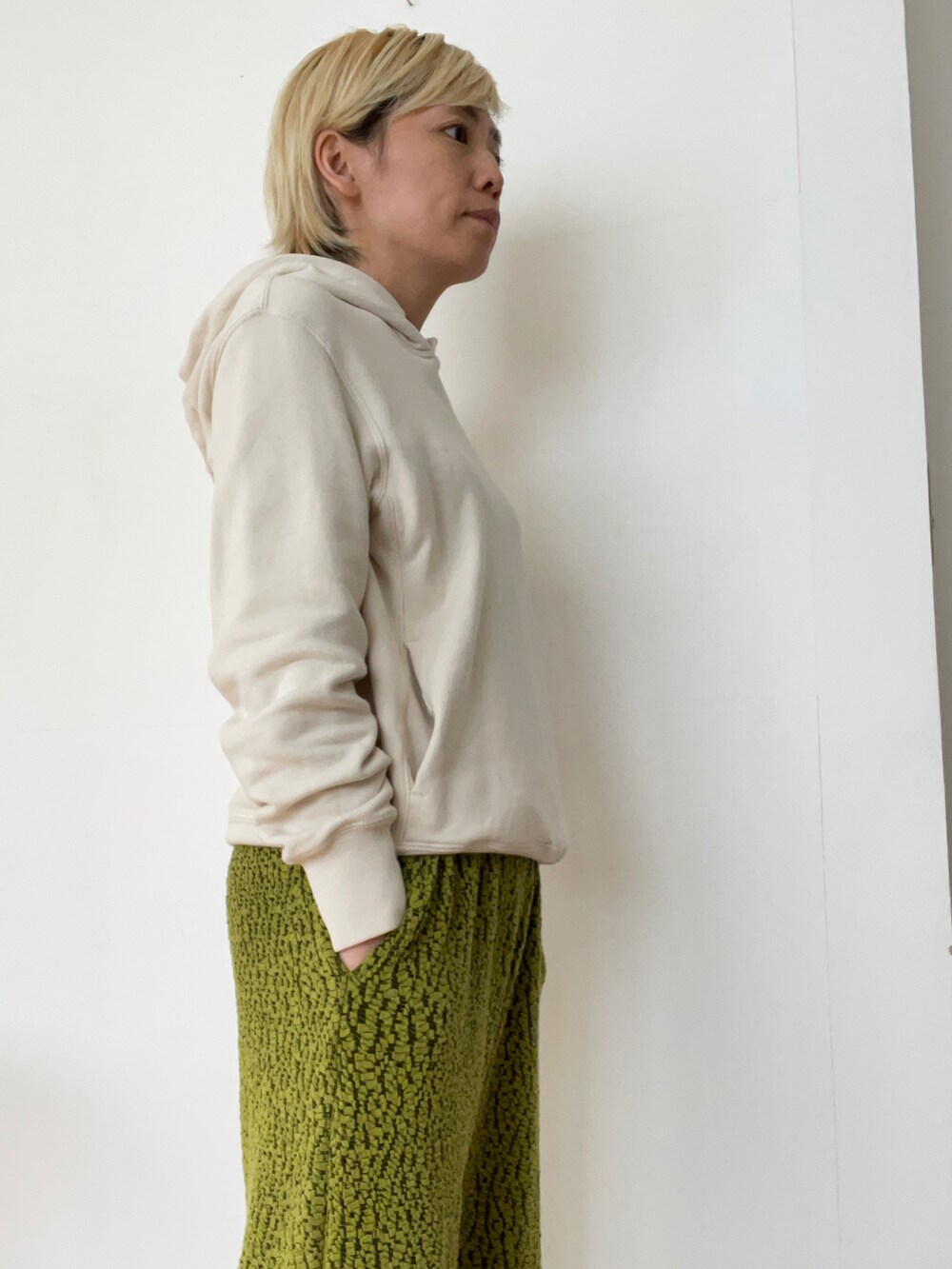 ホワイト系のパーカー、グリーン系のその他パンツを着用したレディースの春コーディネートの2枚目の写真