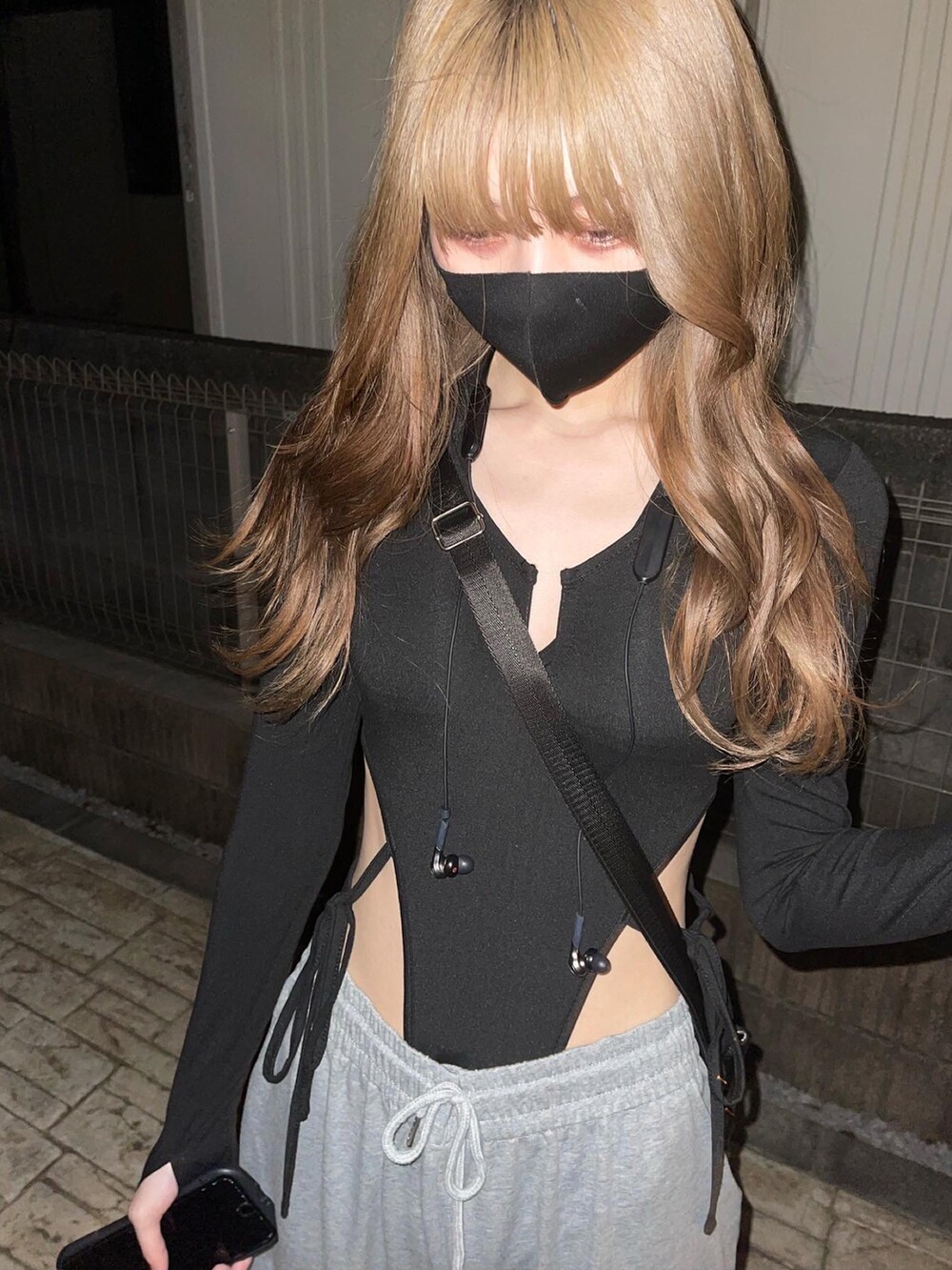 ブラック系のトップス、グレー系のスウェットパンツ、ホワイト系のスニーカーを着用したレディースの春コーディネートの3枚目の写真