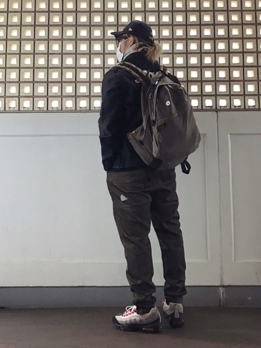 ブラック系のミリタリージャケット、ブラック系のTシャツ/カットソー、グリーン系のバックパック/リュックを着用したメンズの冬コーディネートの2枚目の写真