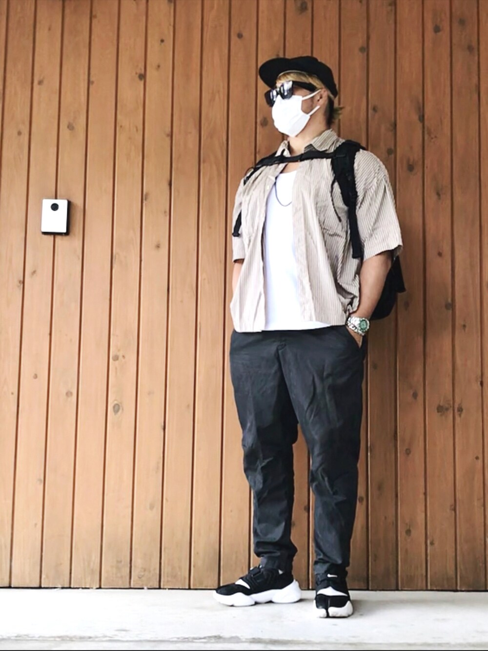 ホワイト系のタンクトップ、ブラック系のバックパック/リュック、ブラック系のその他パンツを着用したメンズの夏コーディネートの2枚目の写真