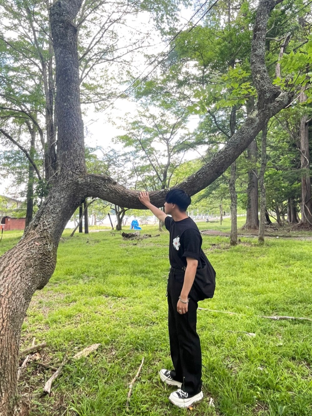 ブラック系のTシャツ/カットソー、ブラック系のスラックス、ブラック系のスニーカーを着用したメンズの夏コーディネートの2枚目の写真