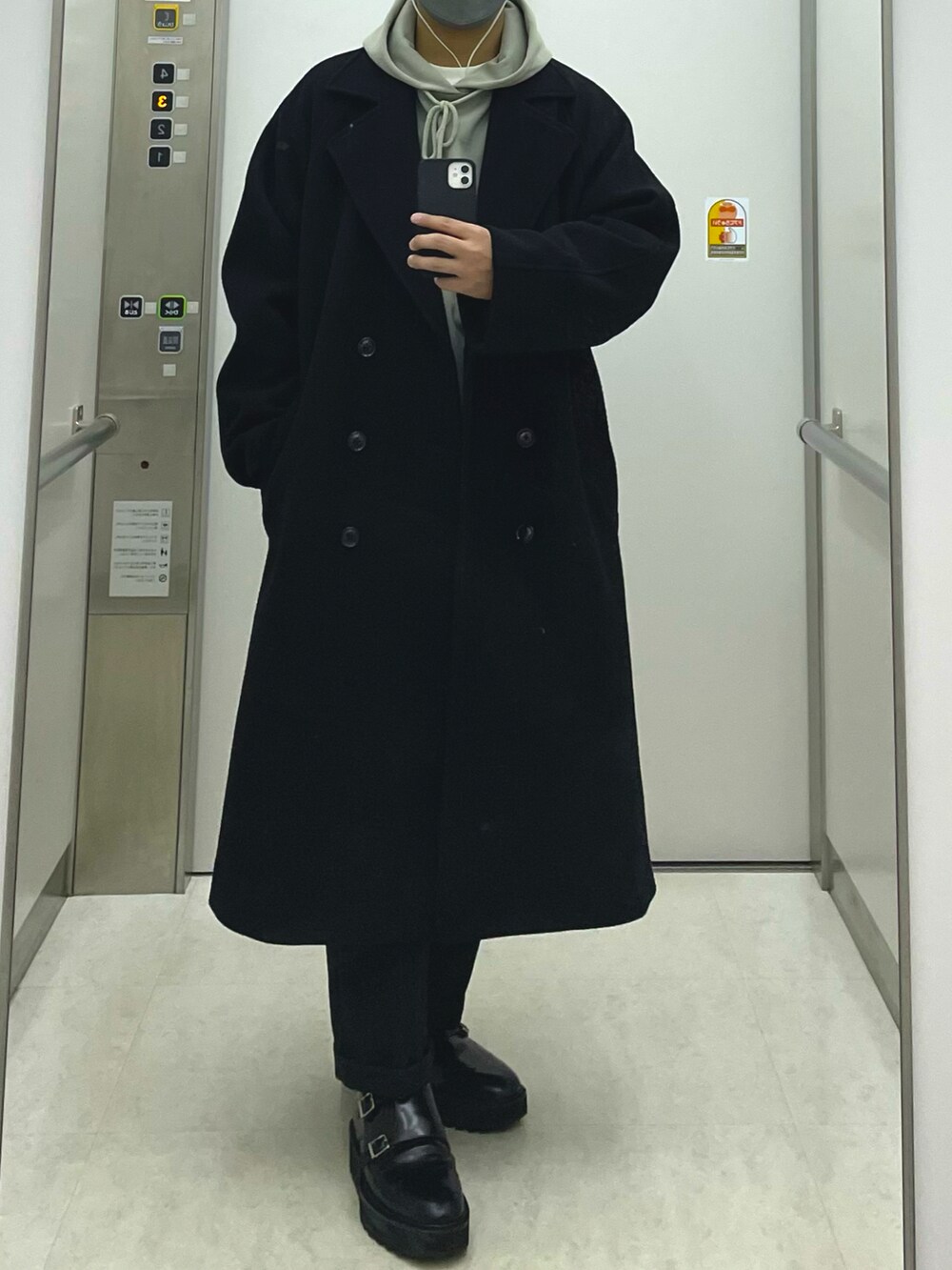 ブラック系のチェスターコート、ブラック系のチノパンツ、ブラック系のドレスシューズを着用したメンズの冬コーディネートの2枚目の写真