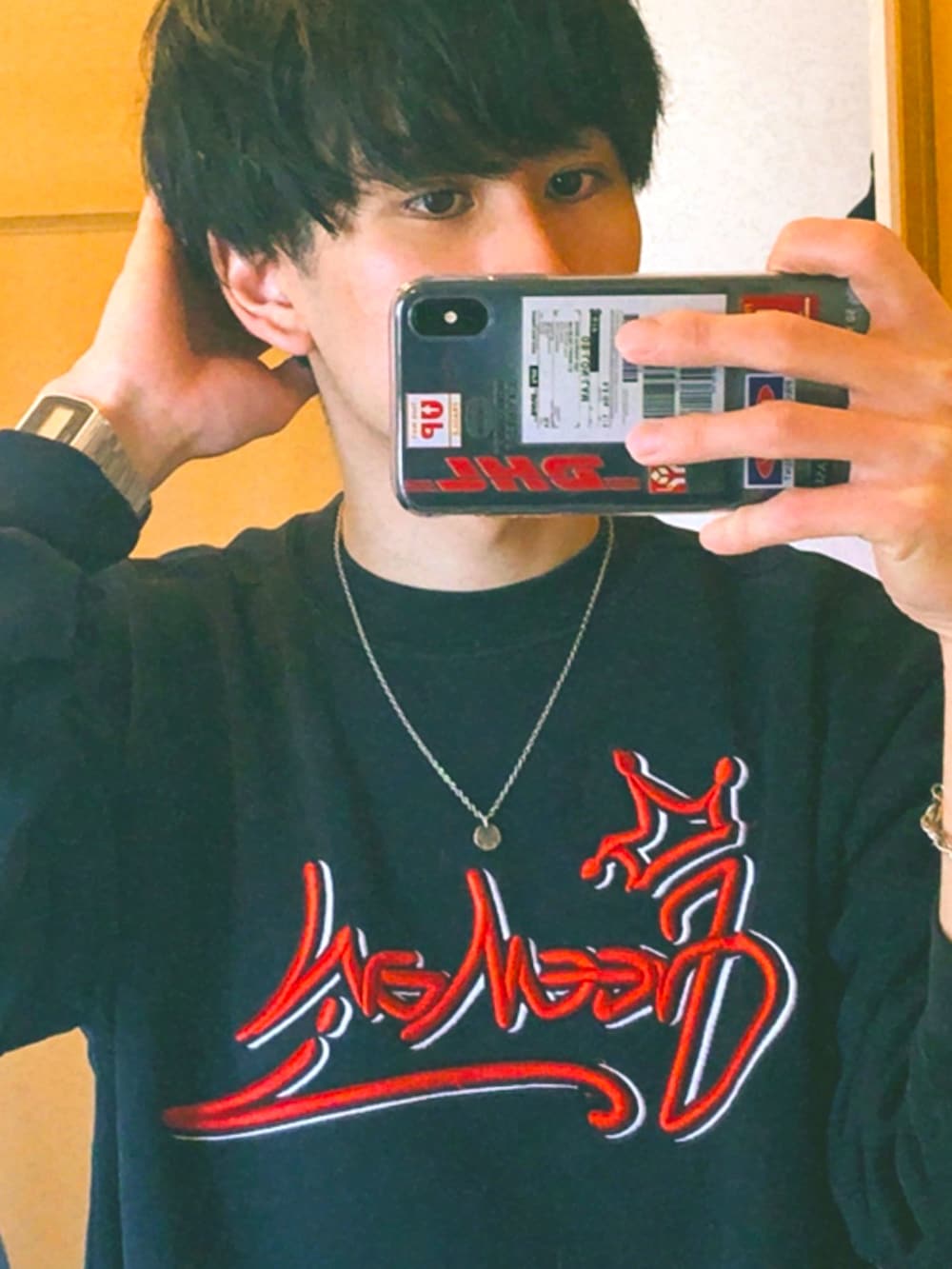 イエロー系のスニーカー、ブラック系のデニムパンツ、グレー系のデジタル腕時計を着用したメンズの冬コーディネートの2枚目の写真