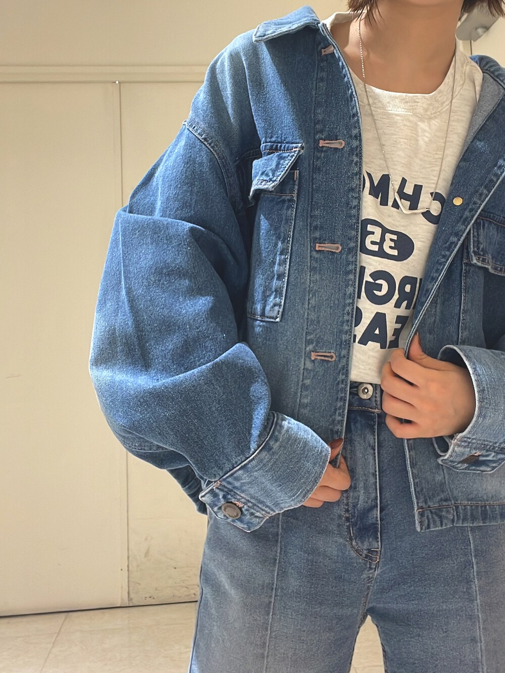 ブルー系のデニムジャケット、グレー系のTシャツ/カットソー、ブルー系のデニムパンツを着用したレディースの冬コーディネートの2枚目の写真