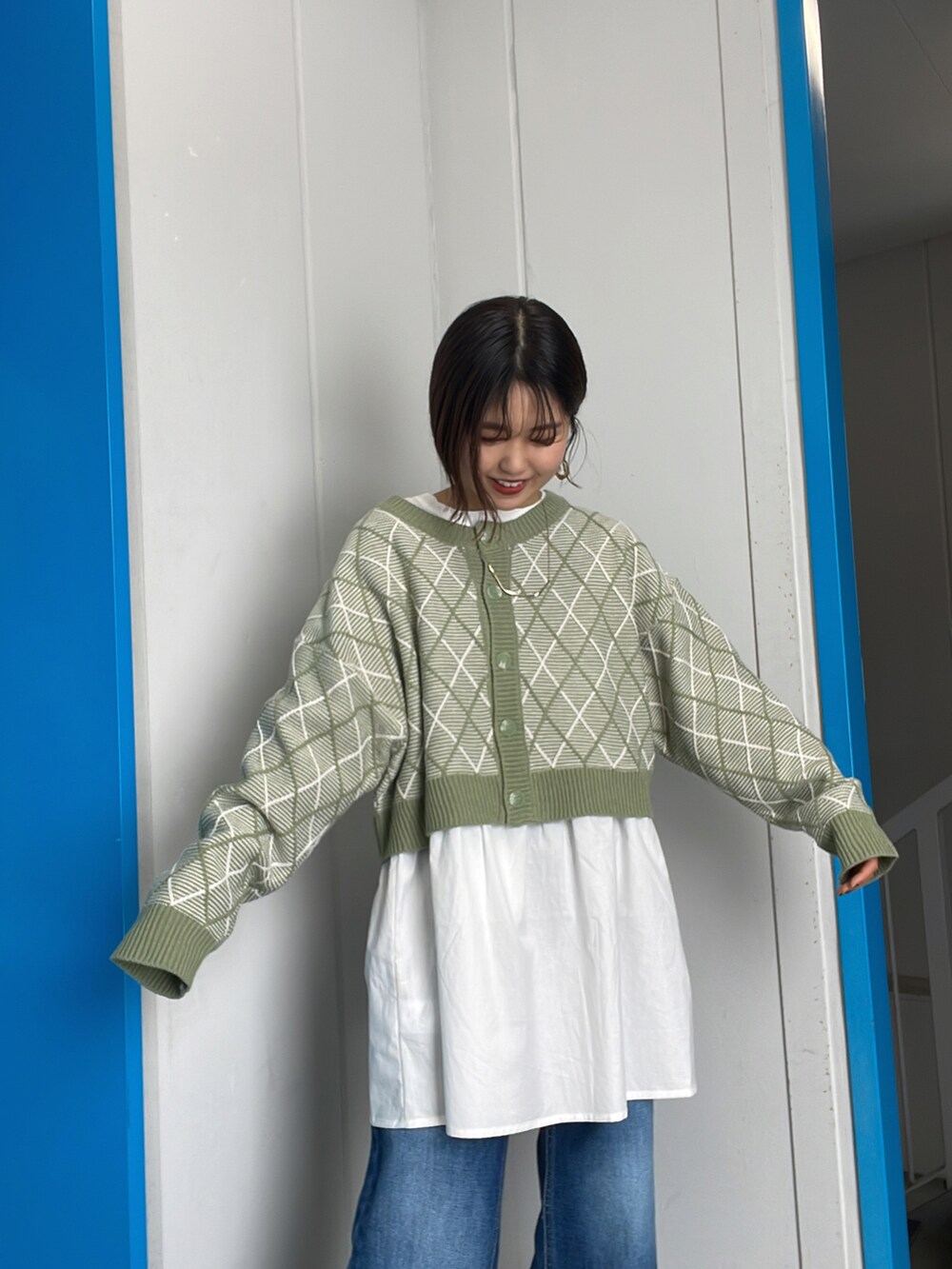 グリーン系のカーディガン/ボレロ、ブルー系のデニムパンツを着用したレディースの冬コーディネートの2枚目の写真