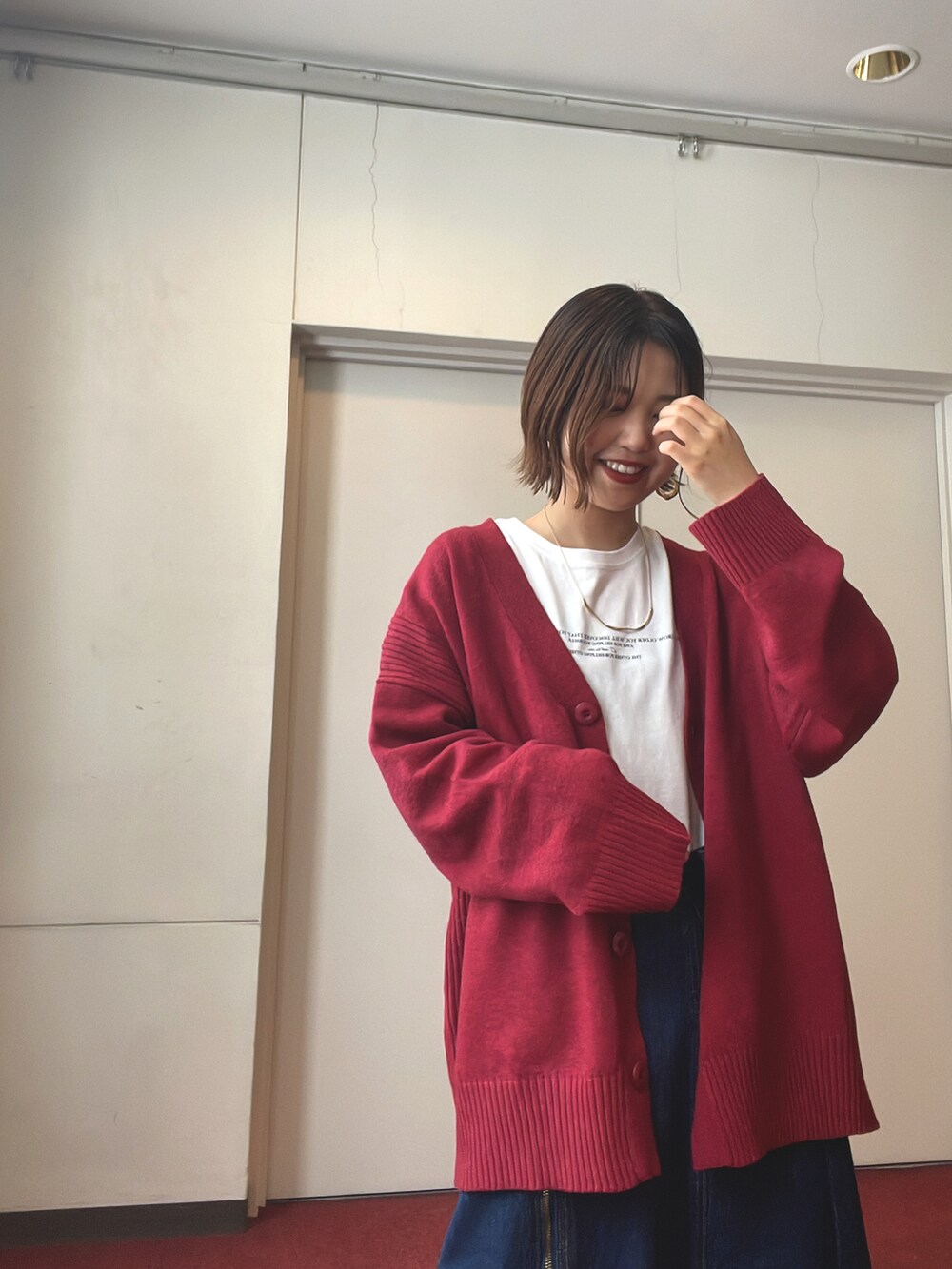 ホワイト系のTシャツ/カットソー、ピンク系のカーディガン/ボレロ、ブルー系のデニムスカートを着用したレディースの冬コーディネートの2枚目の写真