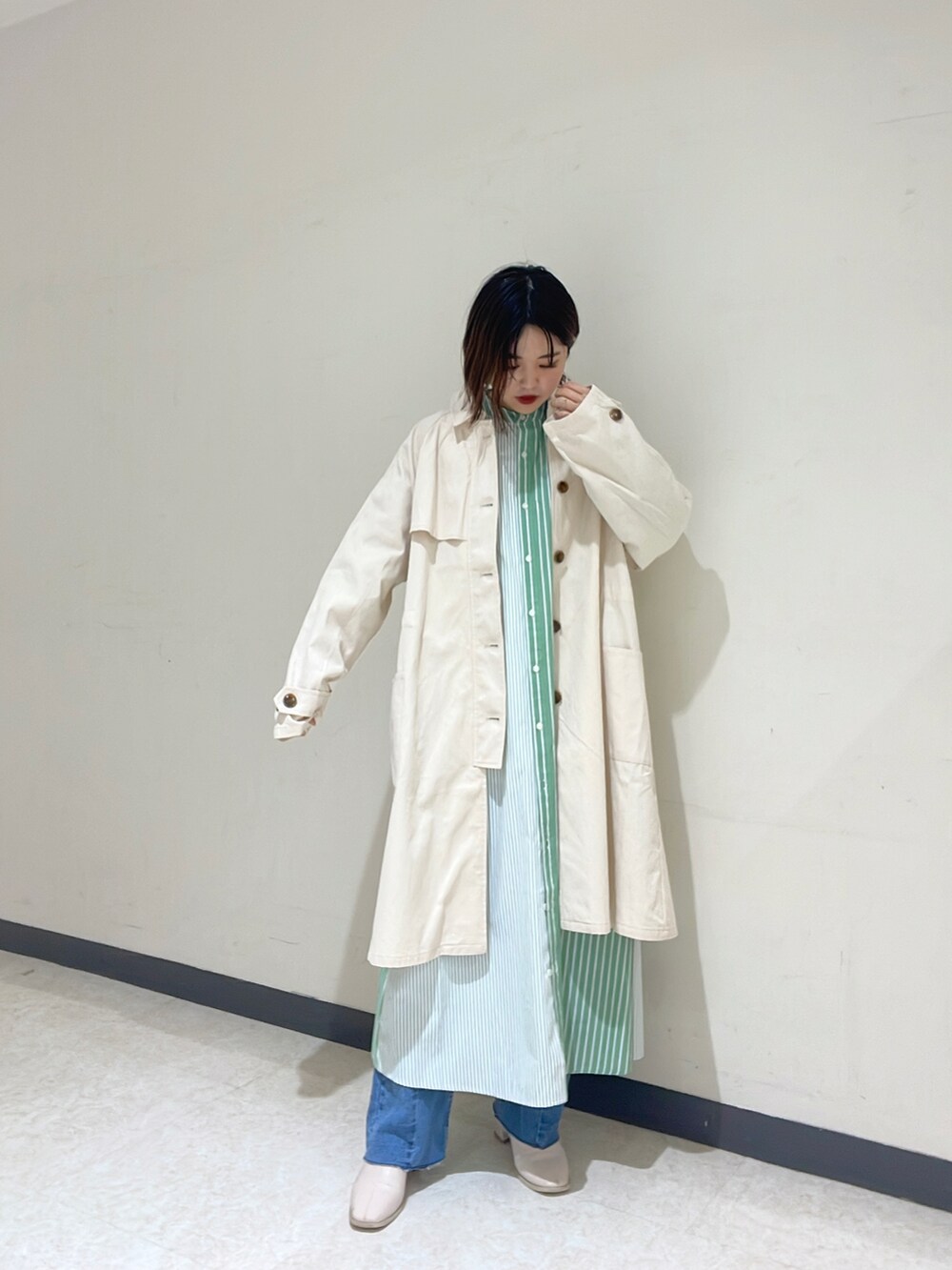 ホワイト系のカーディガン/ボレロ、グリーン系のシャツワンピース、ブルー系のデニムパンツを着用したレディースの冬コーディネートの2枚目の写真