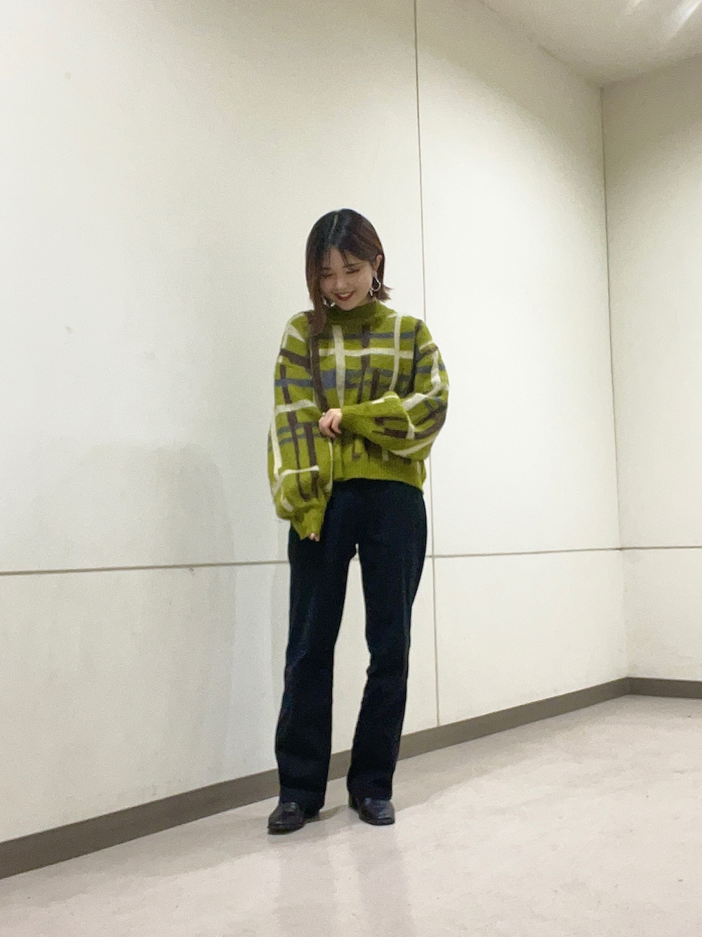 グリーン系のニット/セーター、ブラック系のその他パンツを着用したレディースの冬コーディネートの2枚目の写真