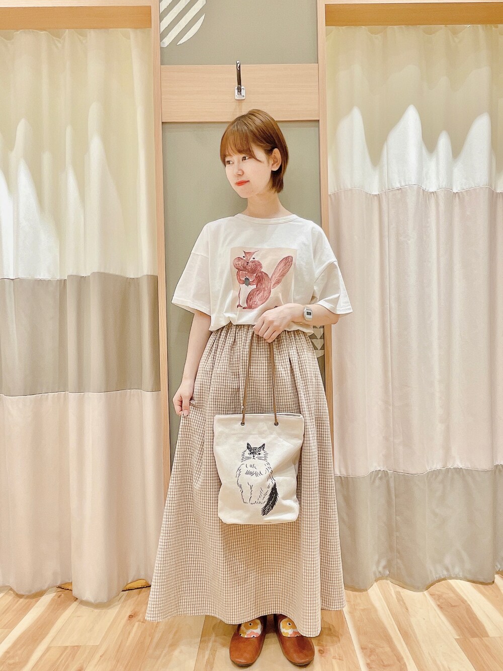 ベージュ系のベスト、ベージュ系のスカート、ホワイト系のTシャツ/カットソーを着用したレディースの夏コーディネートの2枚目の写真