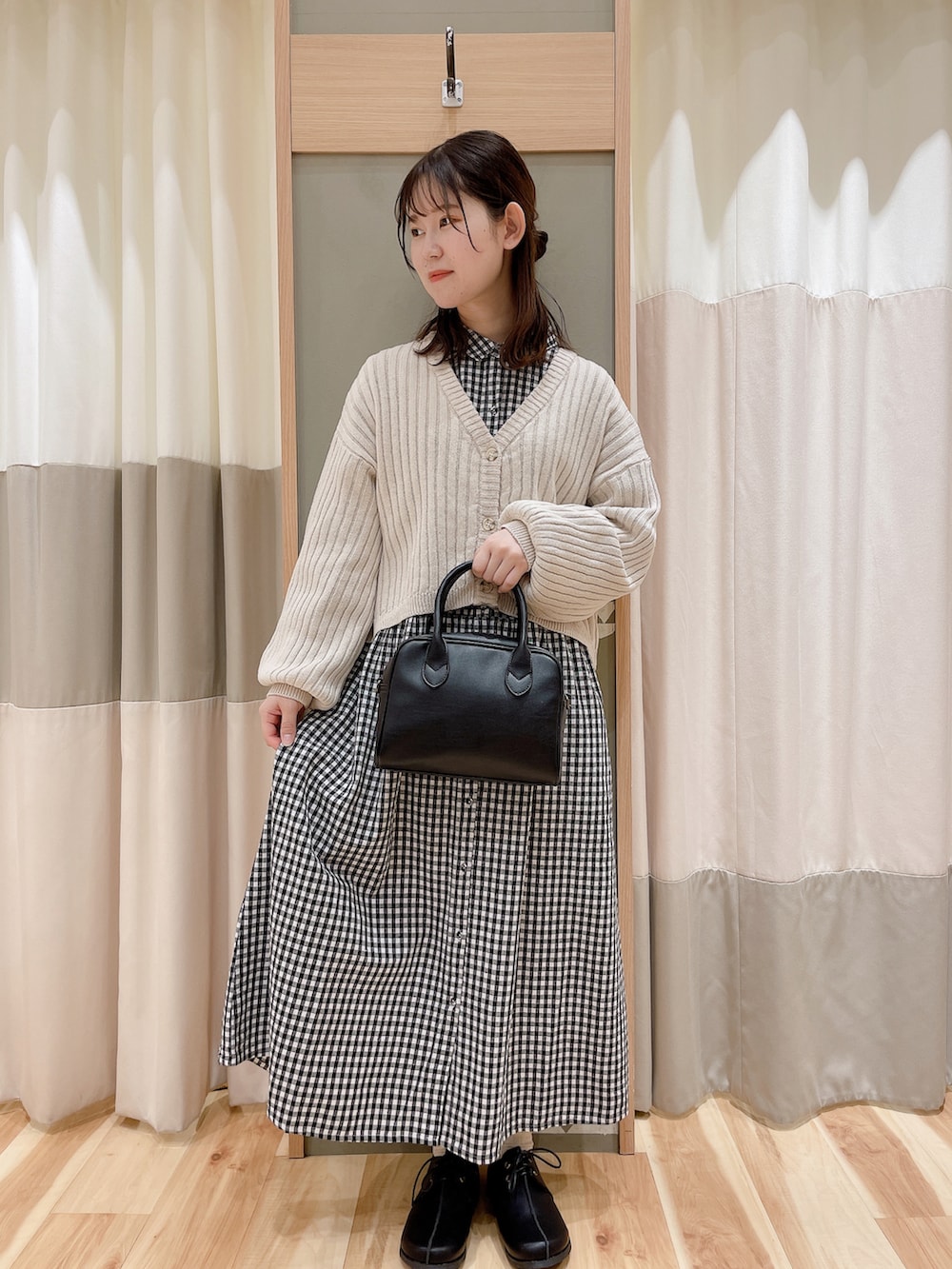 ブラック系のワンピース/ドレス、グリーン系のノーカラージャケット、ホワイト系のカーディガン/ボレロを着用したレディースの冬コーディネートの2枚目の写真