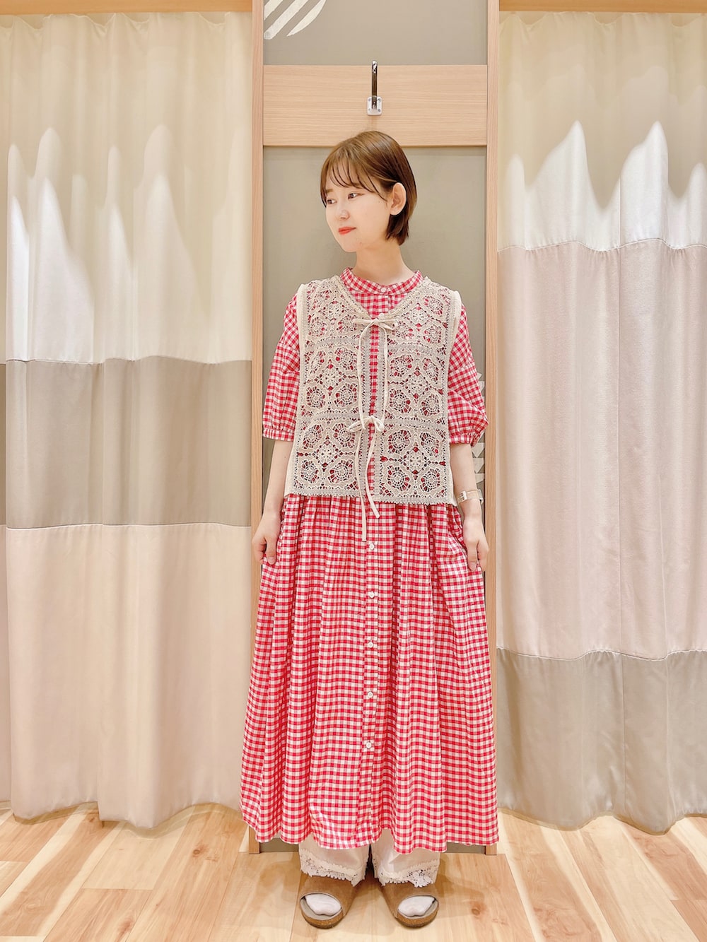 レッド系のワンピース、ホワイト系のベスト、ホワイト系のその他パンツを着用したレディースの夏コーディネートの2枚目の写真