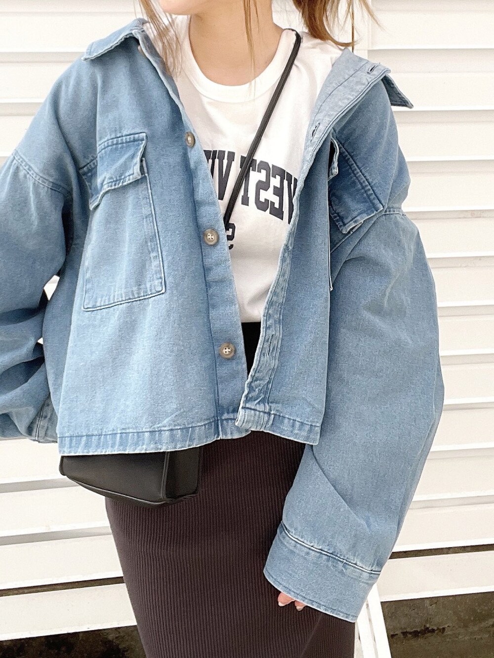 ホワイト系のTシャツ/カットソー、ブラック系のショルダーバッグ、ブラック系のスカートを着用したレディースの冬コーディネートの3枚目の写真