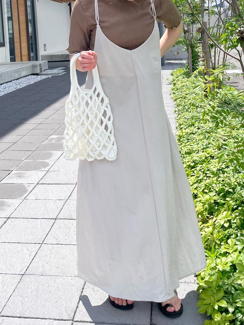 ベージュ系のワンピース、ブラウン系のTシャツ/カットソーを着用したレディースの春コーディネートの2枚目の写真