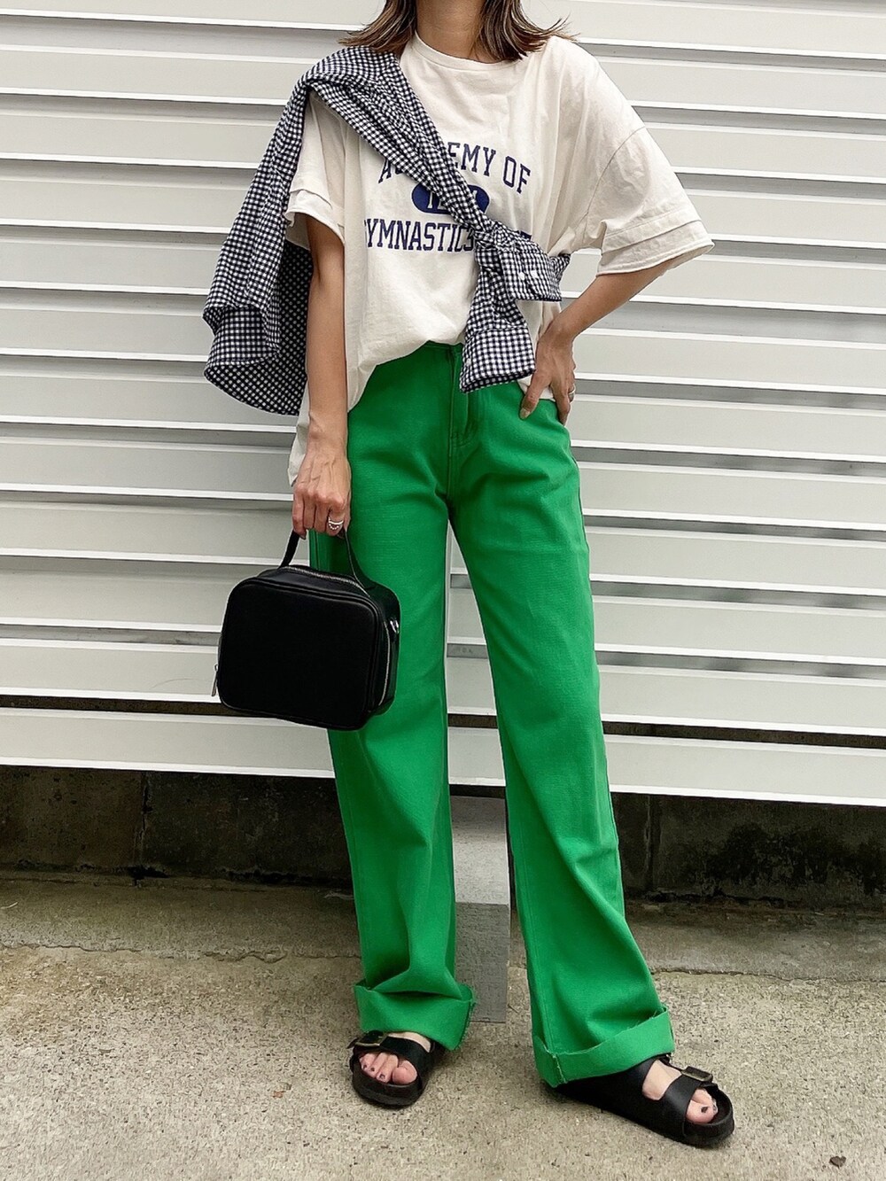 グリーン系のデニムパンツ、ホワイト系のTシャツ/カットソー、ブラック系のサンダルを着用したレディースの夏コーディネートの2枚目の写真