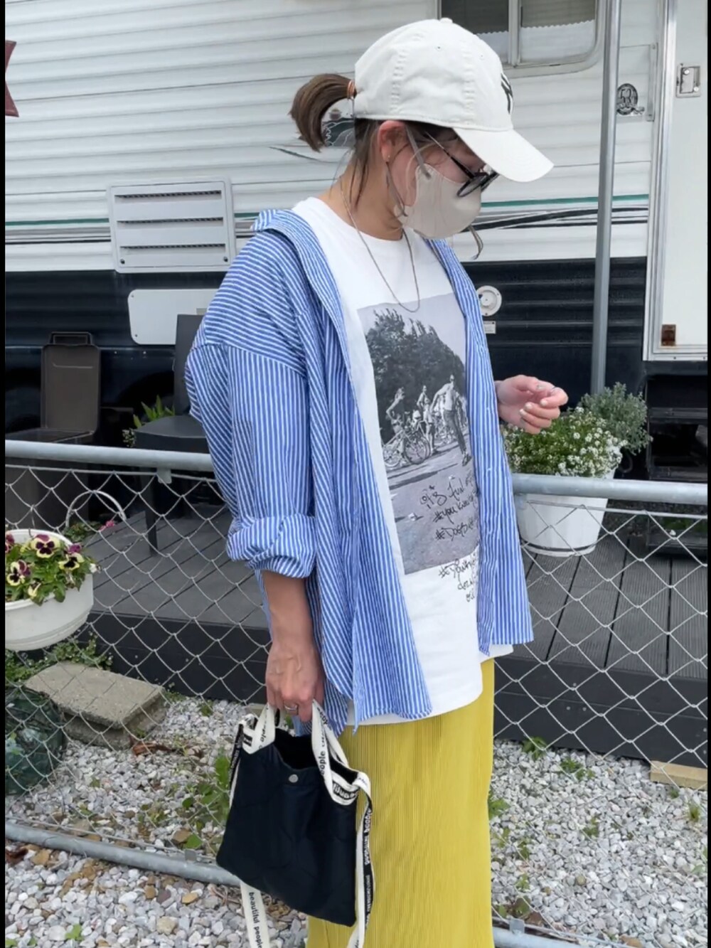 ブルー系のシャツ/ブラウス、ホワイト系のTシャツ/カットソー、イエロー系のスカートを着用したレディースの春コーディネートの2枚目の写真