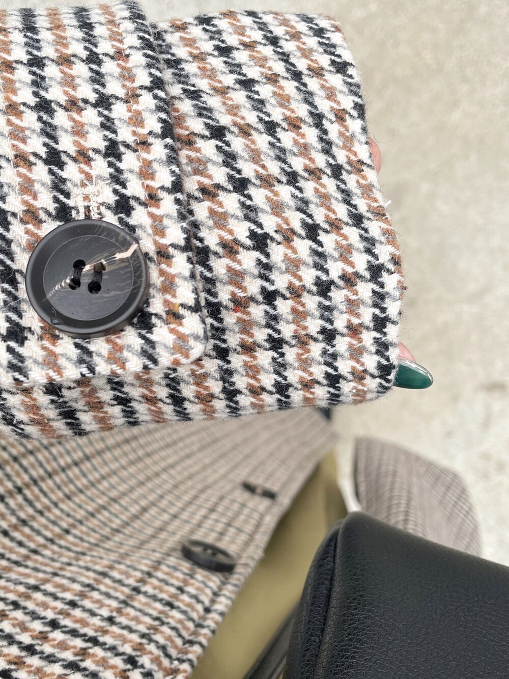 ベージュ系のステンカラーコート、ブラック系のショルダーバッグ、ホワイト系のパーカーを着用したレディースの秋コーディネートの2枚目の写真