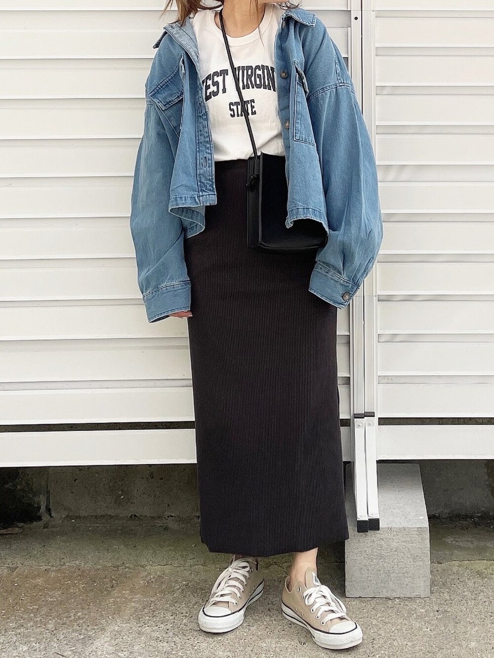 ホワイト系のTシャツ/カットソー、ブラック系のショルダーバッグ、ブラック系のスカートを着用したレディースの冬コーディネートの2枚目の写真