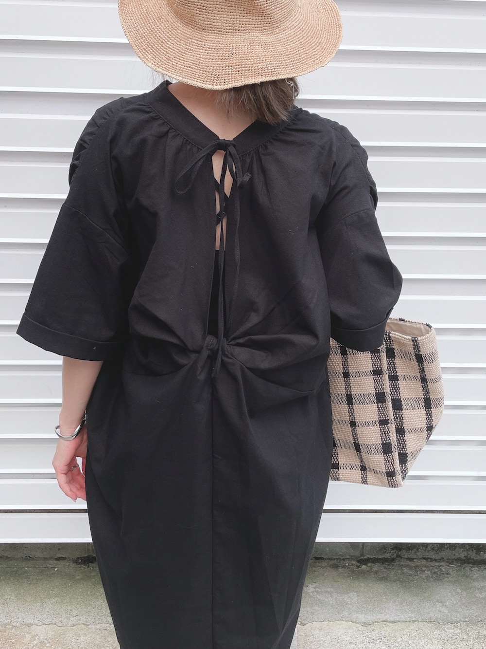 ブラック系のワンピース、ブラック系のサンダル、ブラック系のトートバッグを着用したレディースの夏コーディネートの4枚目の写真