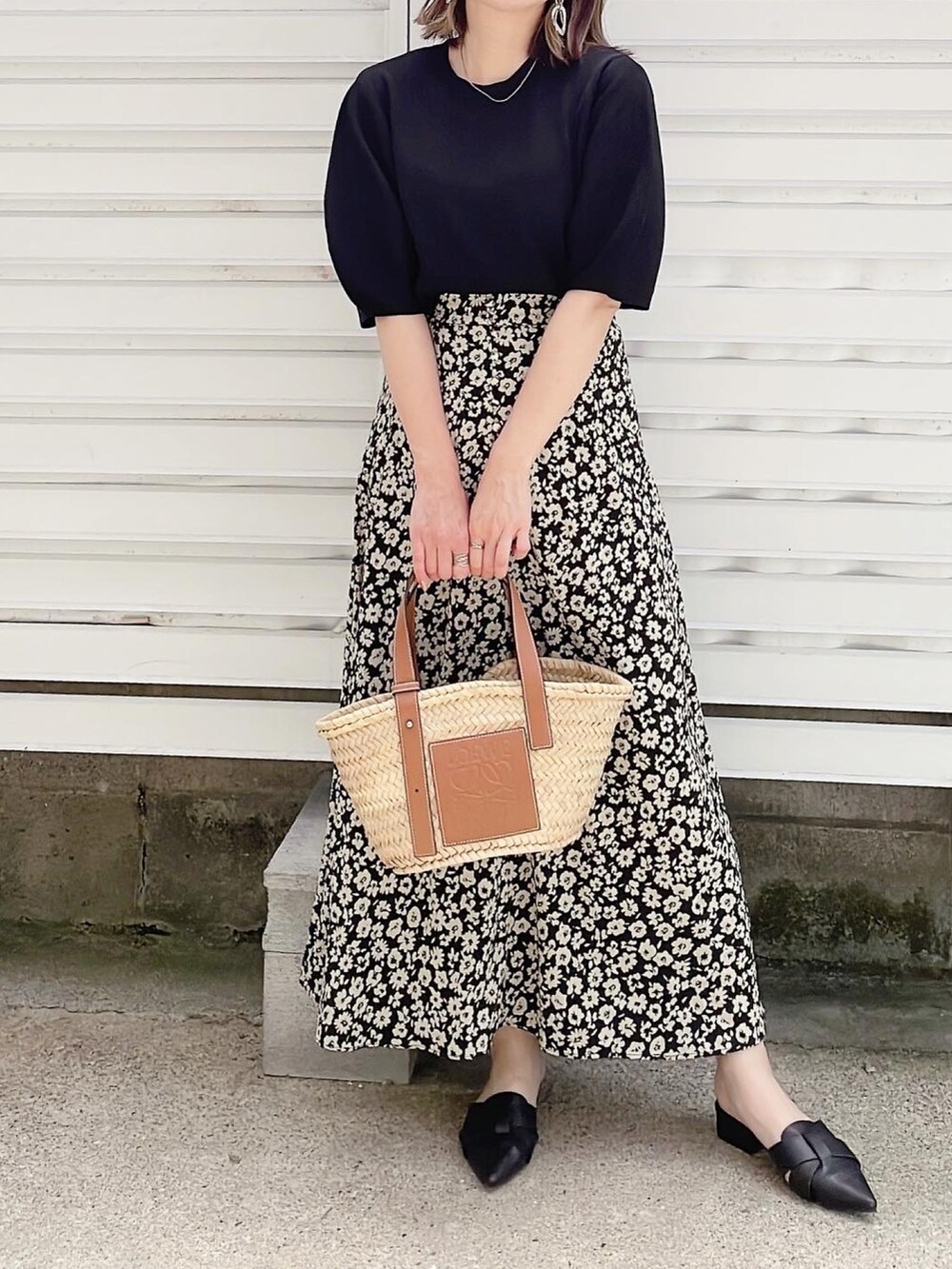 ブラック系のニット/セーター、ブラック系のスカート、ベージュ系のかごバッグを着用したレディースの春コーディネートの2枚目の写真