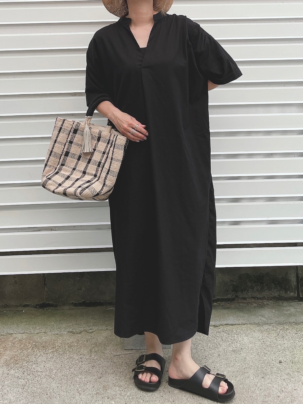 ブラック系のワンピース、ブラック系のサンダル、ブラック系のトートバッグを着用したレディースの夏コーディネートの3枚目の写真