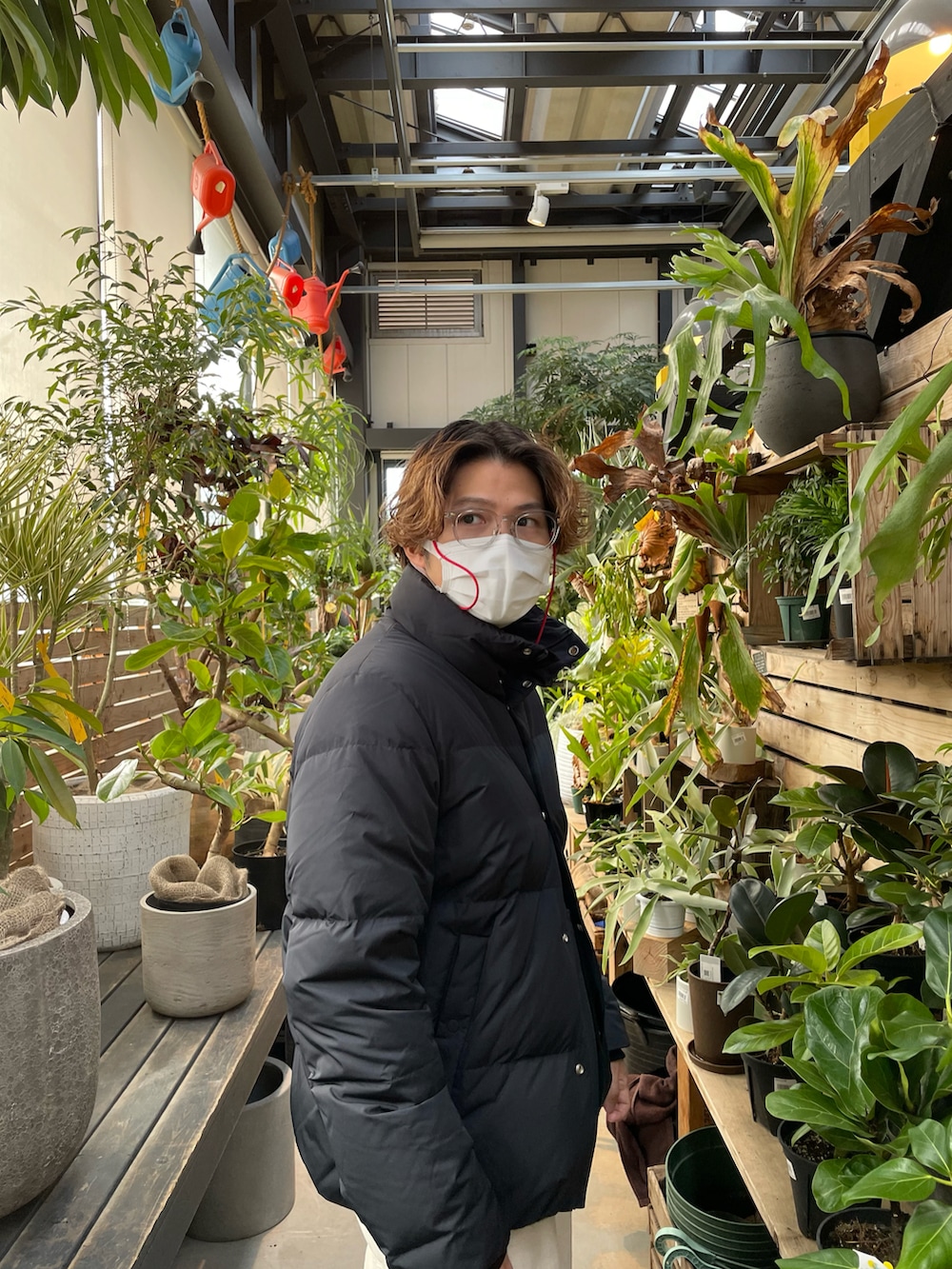 ブラック系のダウンジャケット/コート、ブラック系のニット/セーター、ホワイト系のデニムパンツを着用したメンズの冬コーディネートの2枚目の写真