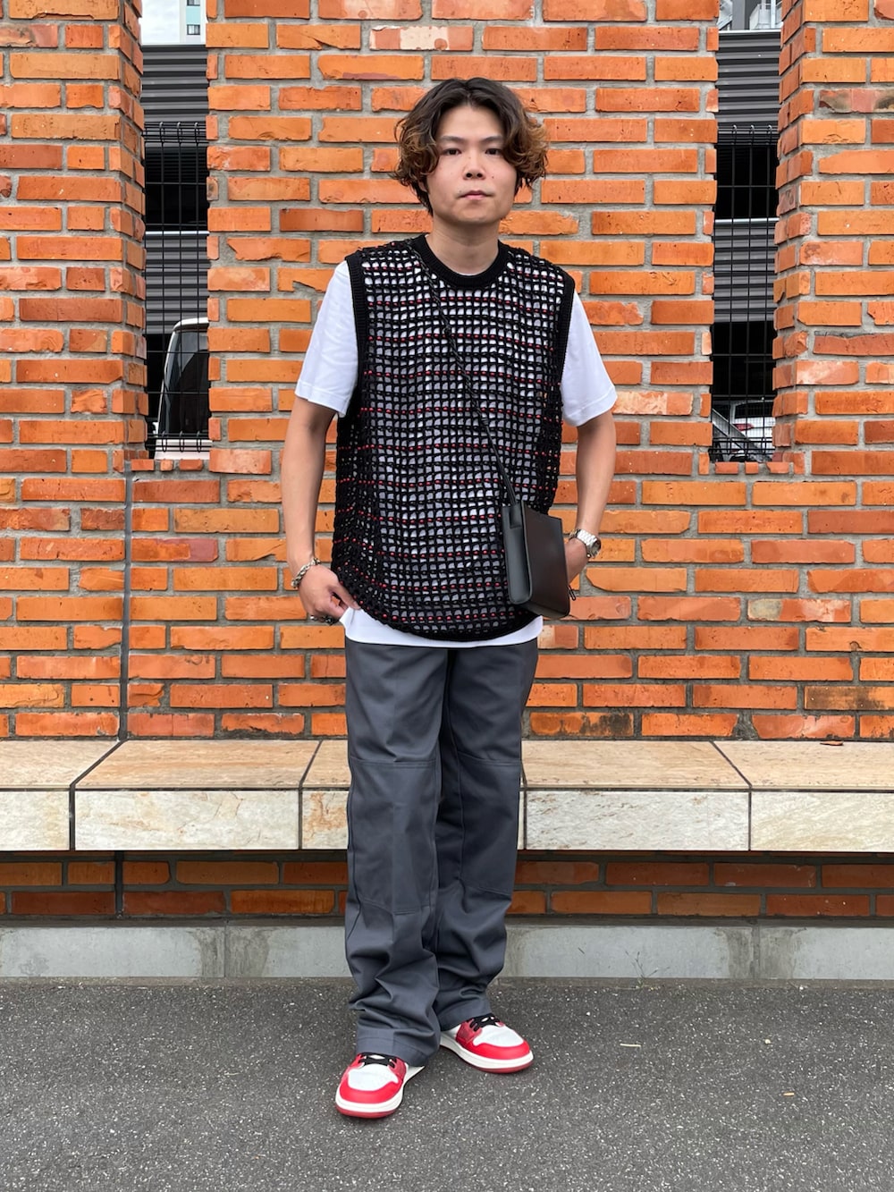 ブラック系のベスト、ホワイト系のTシャツ/カットソー、グレー系のチノパンツを着用したメンズの夏コーディネートの2枚目の写真