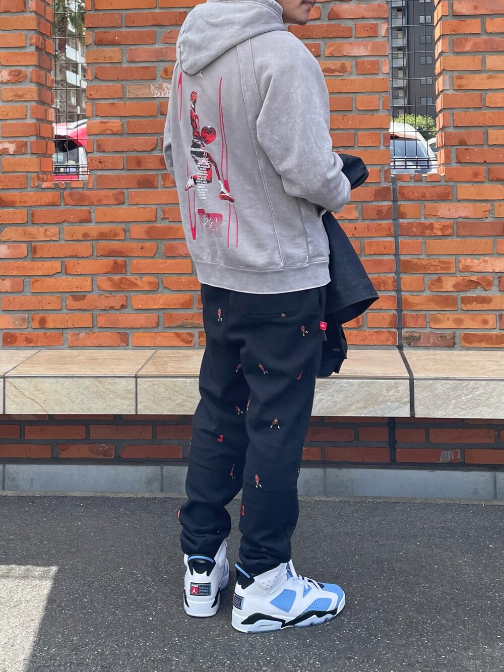 ブルー系のデニムジャケット、ベージュ系のパーカー、ブラック系のその他パンツを着用したメンズの春コーディネートの2枚目の写真