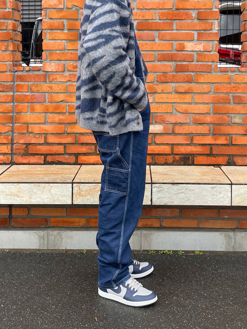 グレー系のカーディガン/ボレロ、ブラック系のTシャツ/カットソー、ブルー系のサロペット/オーバーオールを着用したメンズの冬コーディネートの2枚目の写真