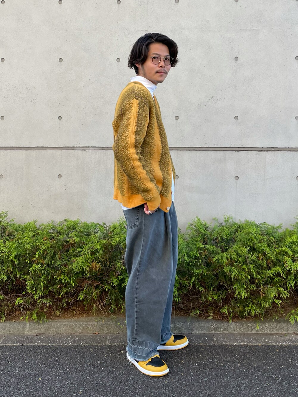 イエロー系のカーディガン/ボレロ、ブラック系のデニムパンツ、イエロー系のスニーカーを着用したメンズの秋コーディネートの2枚目の写真