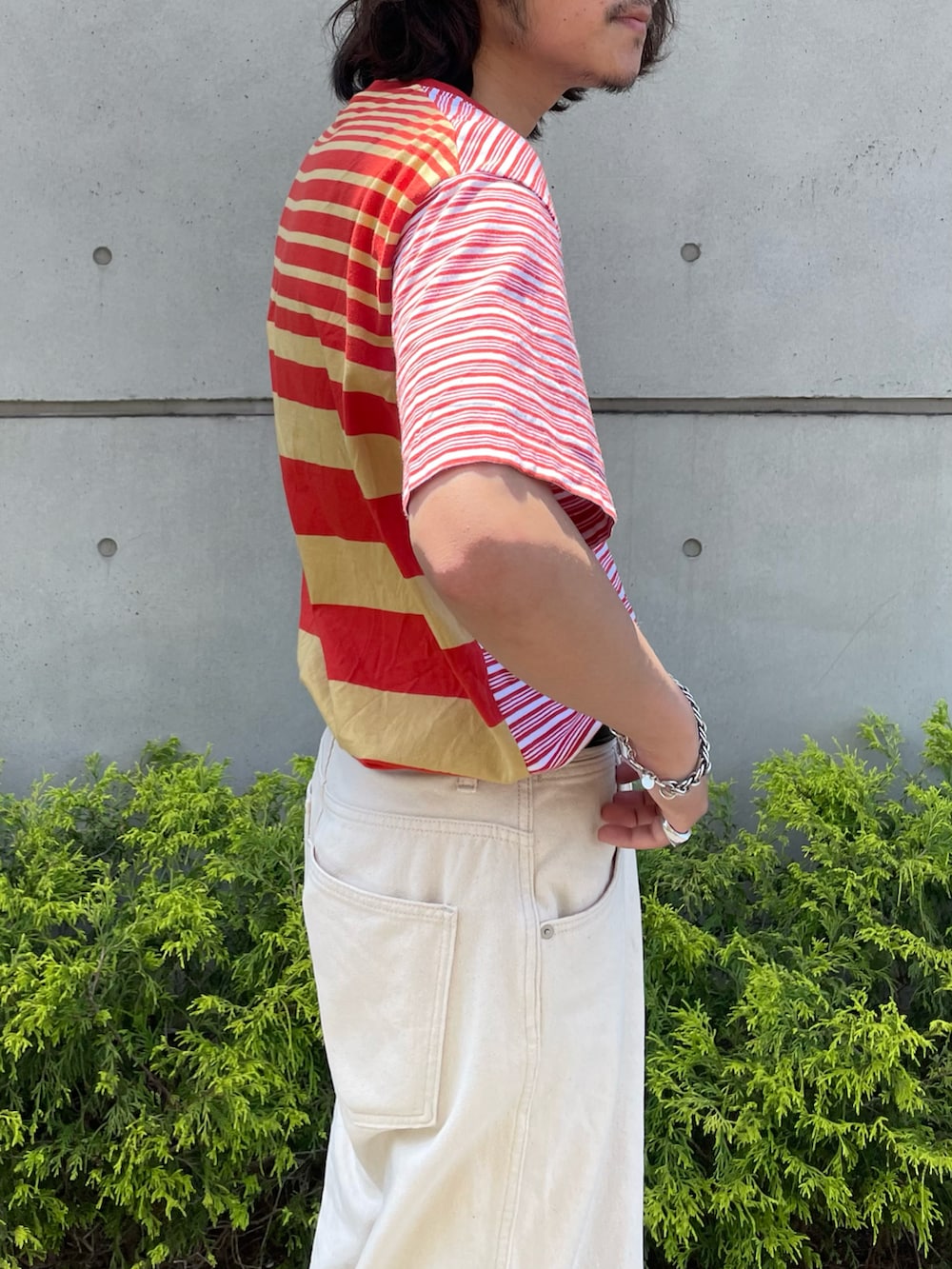 レッド系のTシャツ/カットソー、ホワイト系のデニムパンツ、レッド系のスニーカーを着用したメンズの春コーディネートの2枚目の写真