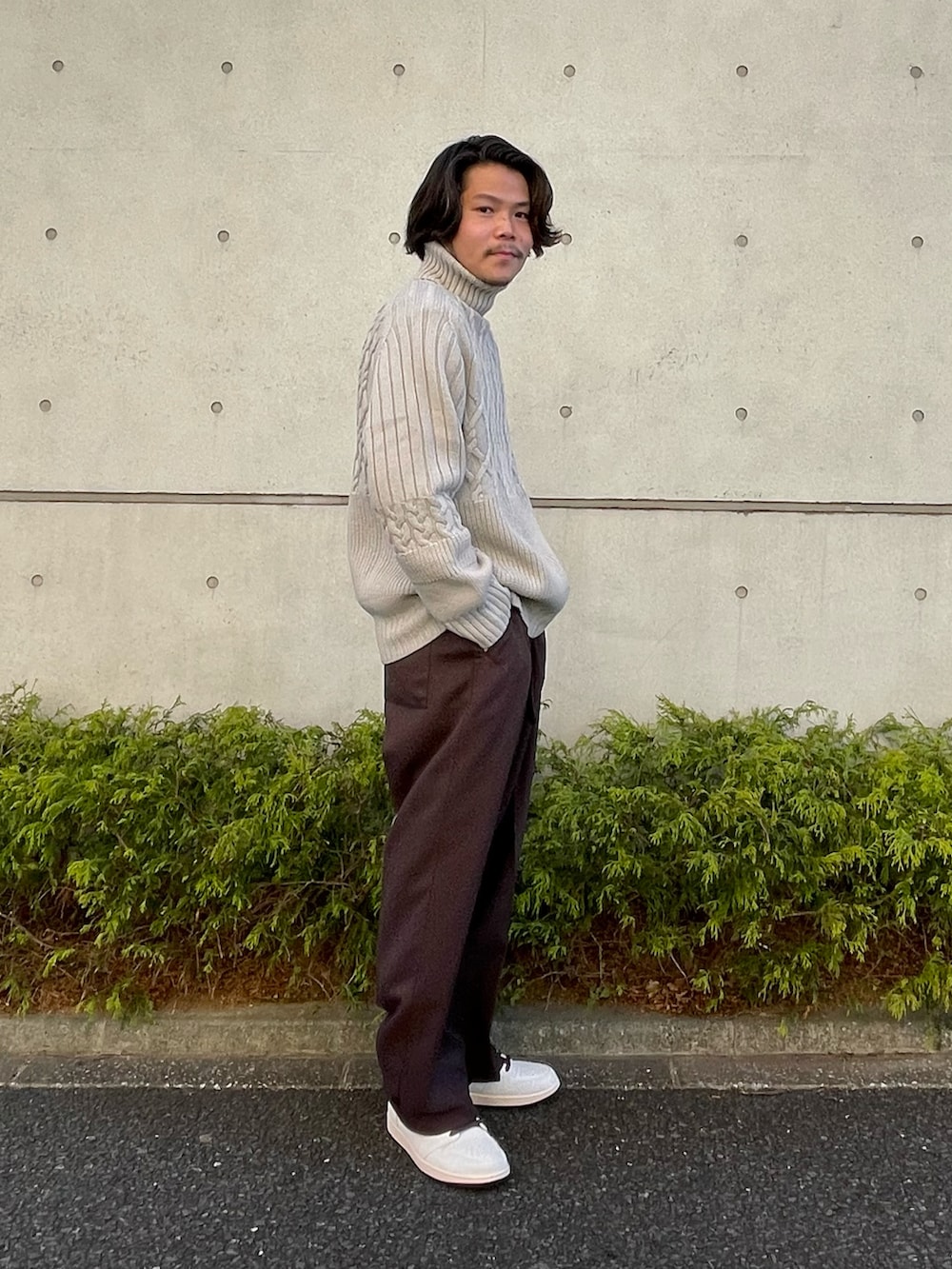 ベージュ系のニット/セーター、ブラウン系のその他パンツ、ホワイト系のスニーカーを着用したメンズの冬コーディネートの2枚目の写真