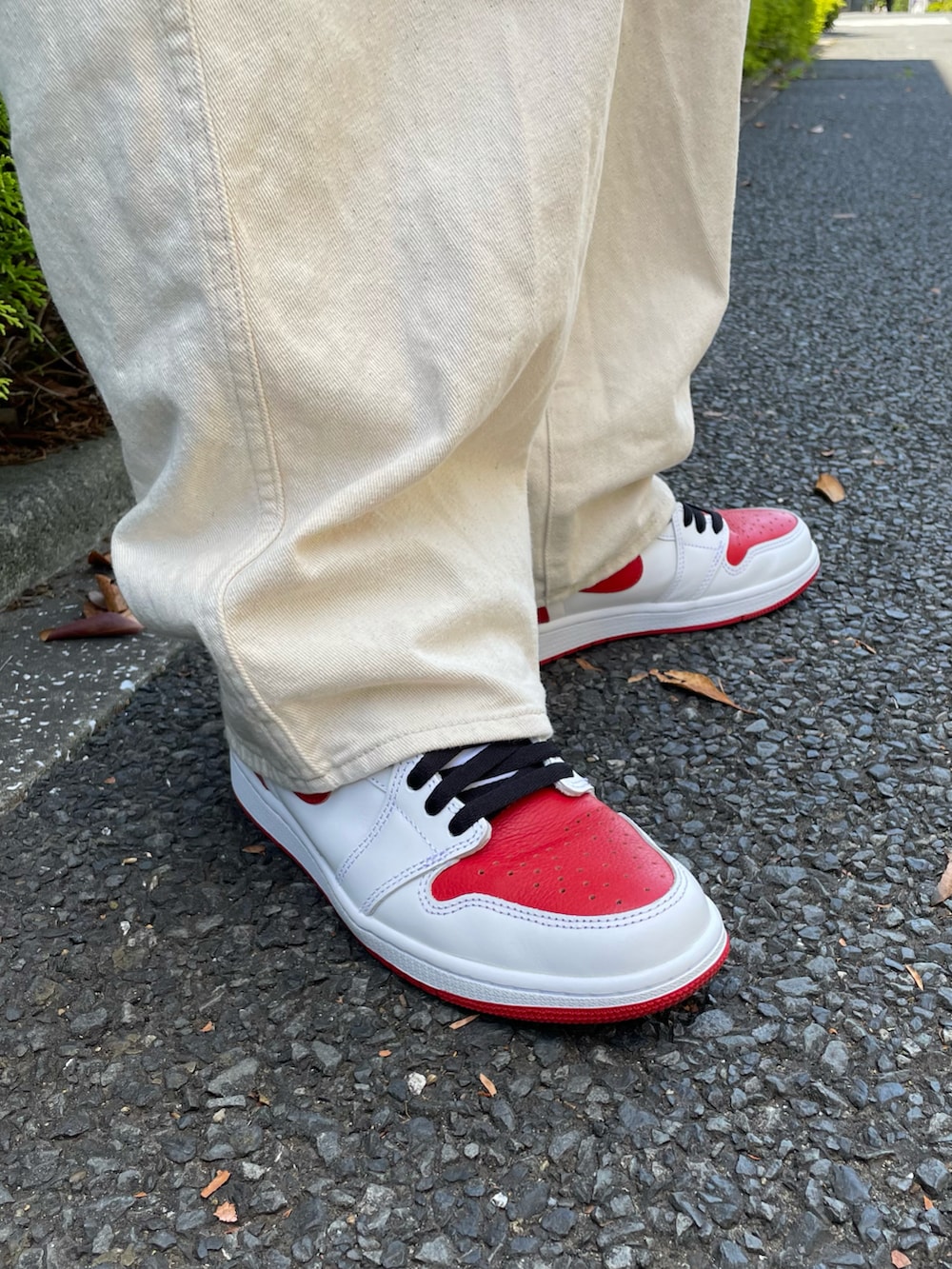 レッド系のTシャツ/カットソー、ホワイト系のデニムパンツ、レッド系のスニーカーを着用したメンズの春コーディネートの3枚目の写真