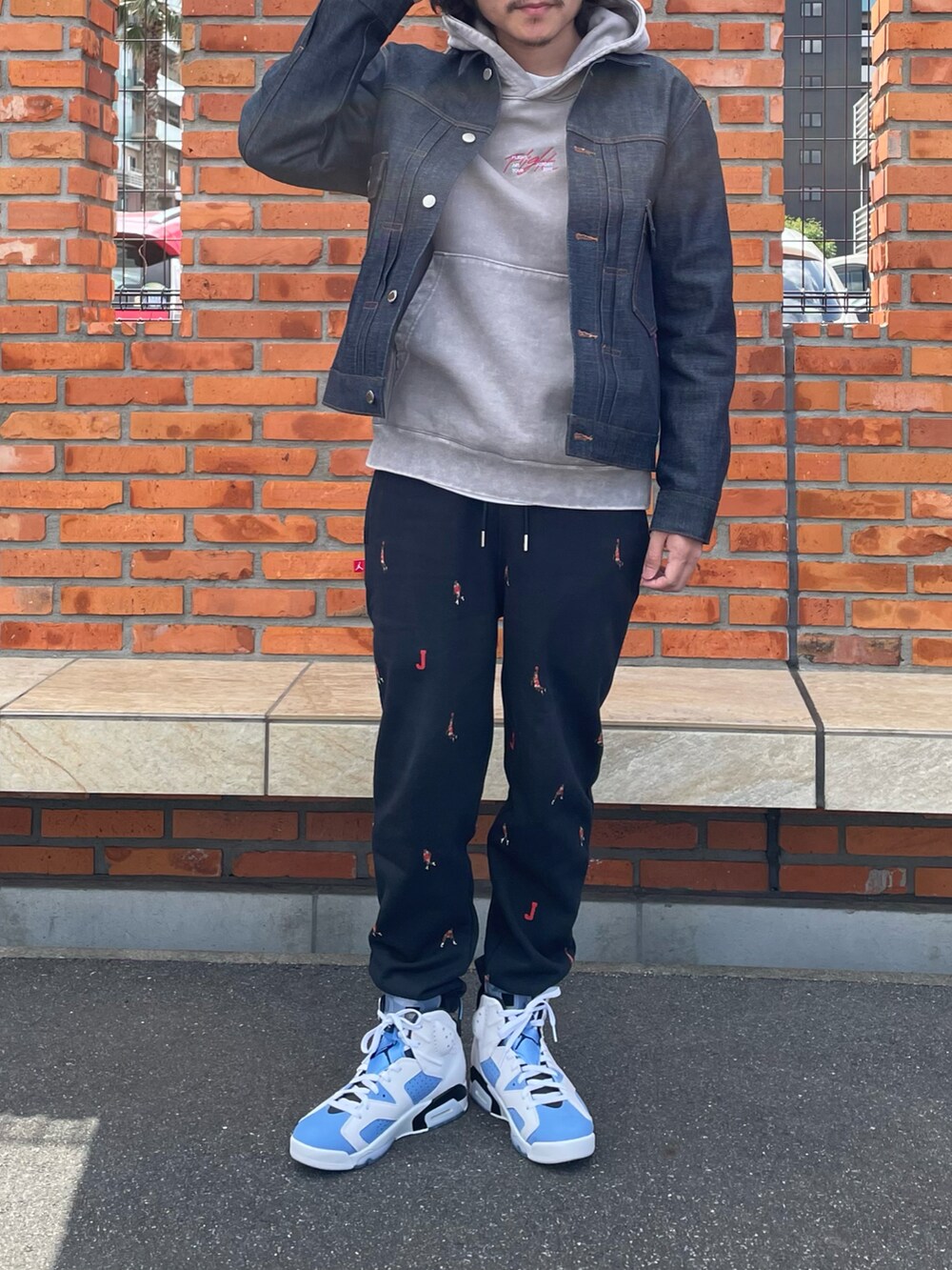 ブルー系のデニムジャケット、ベージュ系のパーカー、ブラック系のその他パンツを着用したメンズの春コーディネートの3枚目の写真