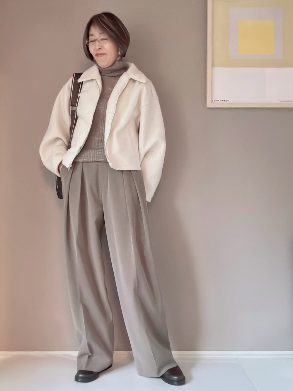 ブラウン系のニット/セーター、ブラウン系のスラックス、ホワイト系のブルゾンを着用したレディースの冬コーディネートの2枚目の写真