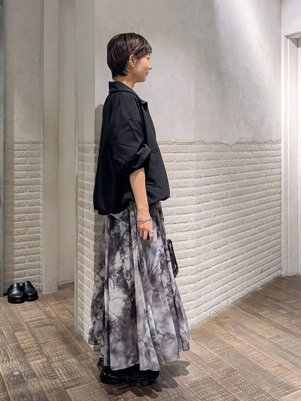 ブラック系のローファー、ブラック系のボストンバッグ、ブラック系のブルゾンを着用したレディースの春コーディネートの4枚目の写真