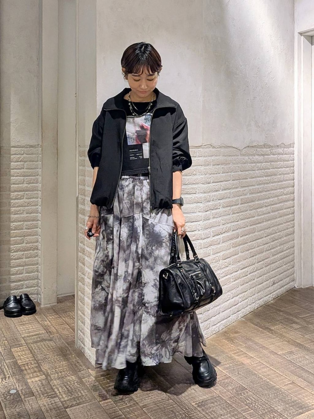 ブラック系のローファー、ブラック系のボストンバッグ、ブラック系のブルゾンを着用したレディースの春コーディネートの2枚目の写真