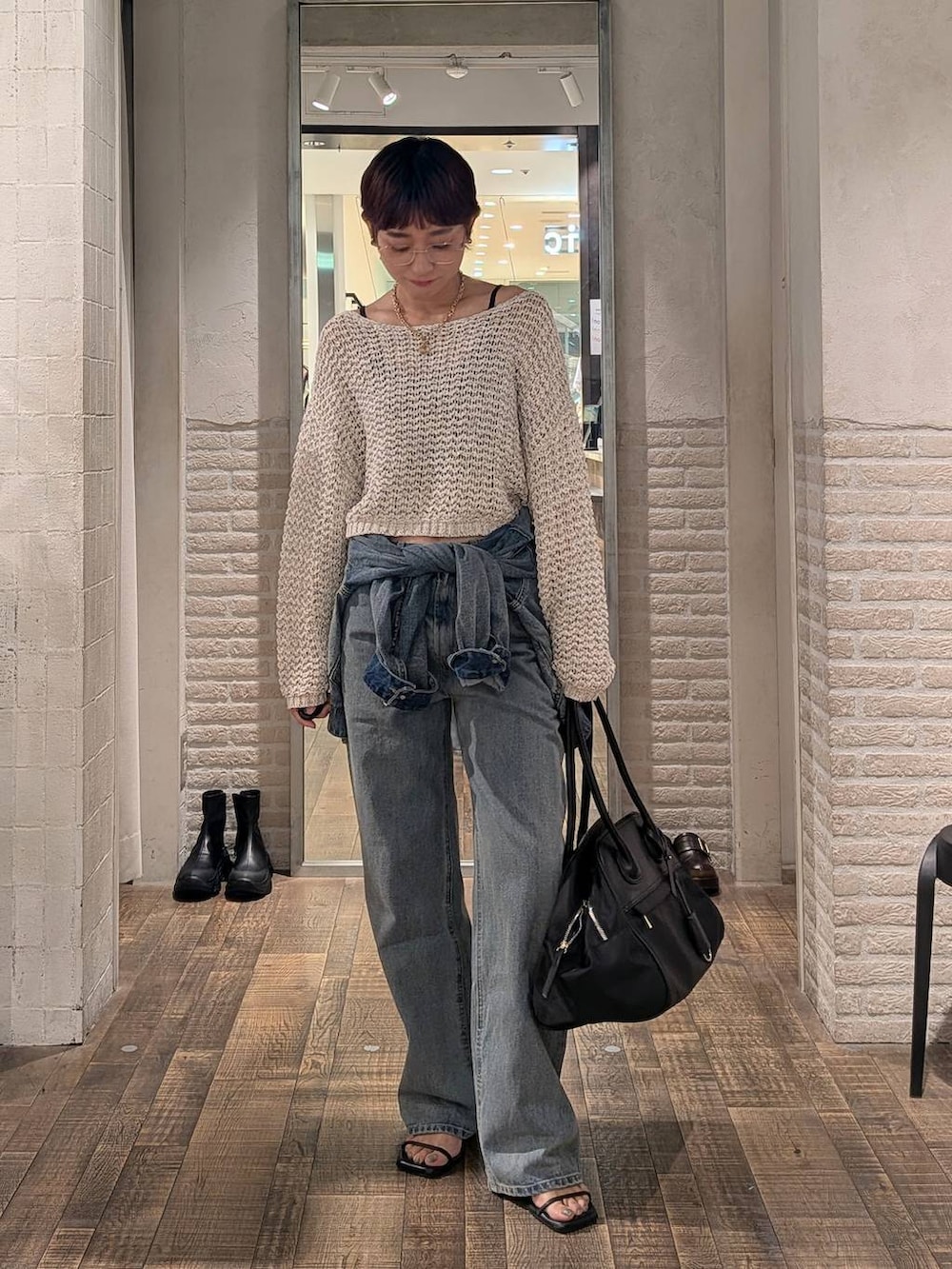 ブルー系のデニムジャケット、ブルー系のデニムパンツ、ブラック系のボストンバッグを着用したレディースの夏コーディネートの3枚目の写真