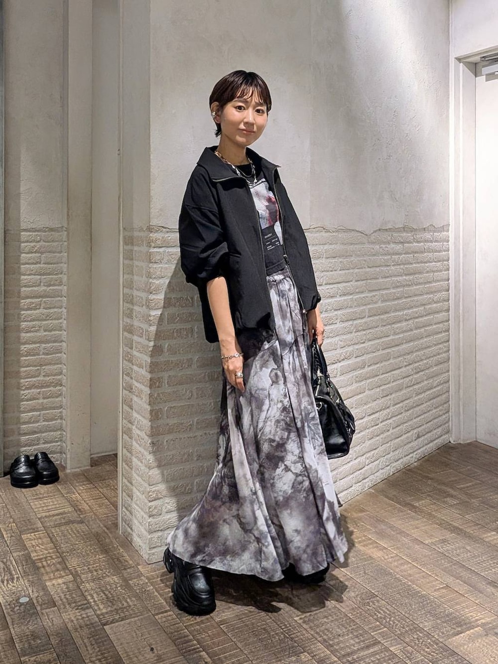 ブラック系のローファー、ブラック系のボストンバッグ、ブラック系のブルゾンを着用したレディースの春コーディネートの3枚目の写真