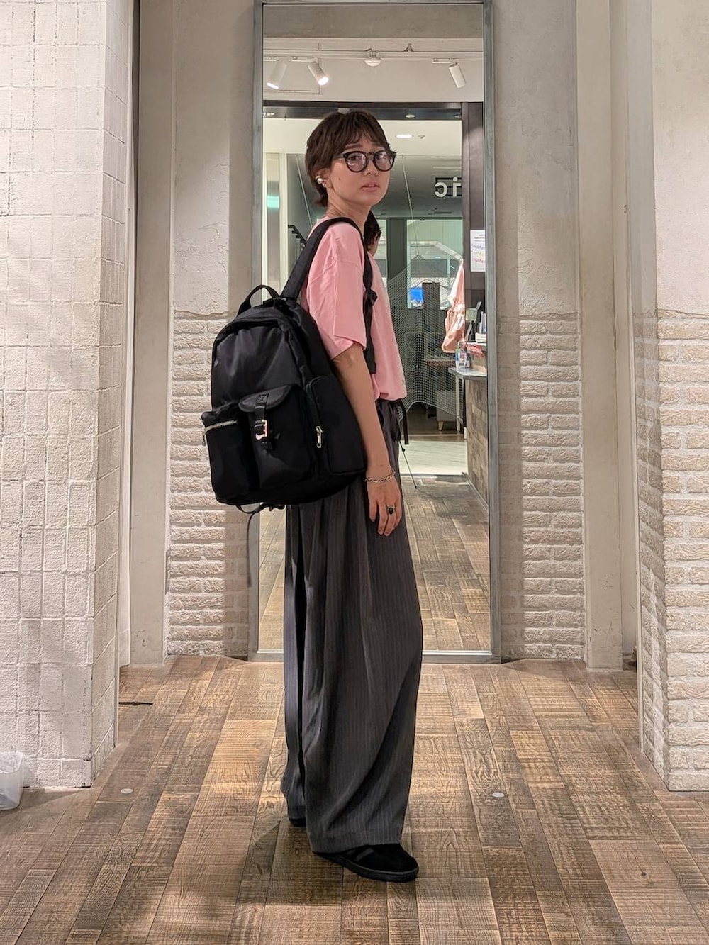 ピンク系のTシャツ/カットソー、ブラック系のバックパック/リュックを着用したレディースの夏コーディネートの2枚目の写真