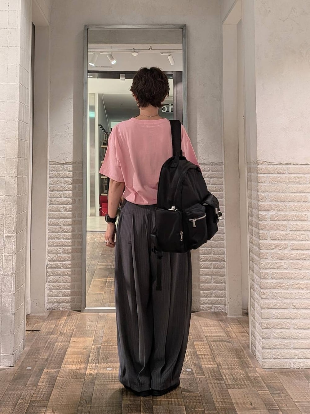 ピンク系のTシャツ/カットソー、ブラック系のバックパック/リュックを着用したレディースの夏コーディネートの3枚目の写真