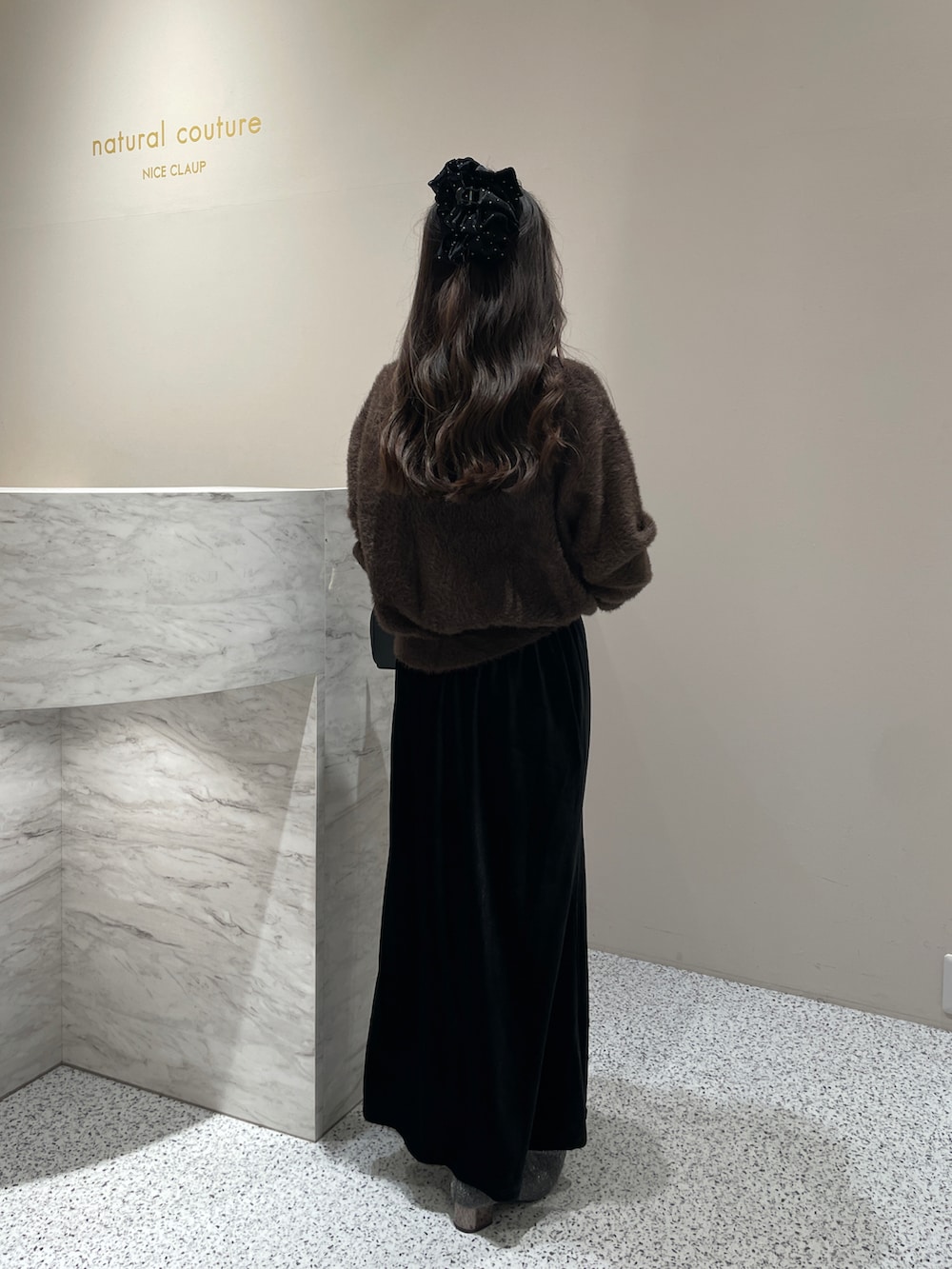 ブラック系のスカート、ブラウン系のカーディガン/ボレロを着用したレディースの秋コーディネートの2枚目の写真